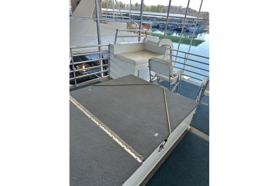 2008 Destination Yachts 45X14 yacht deck with seating and railing, docked by the water.