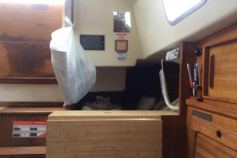 Interior of a 1980 Sloop 27.7 Bristol sailboat with wooden cabinetry and hanging bag.