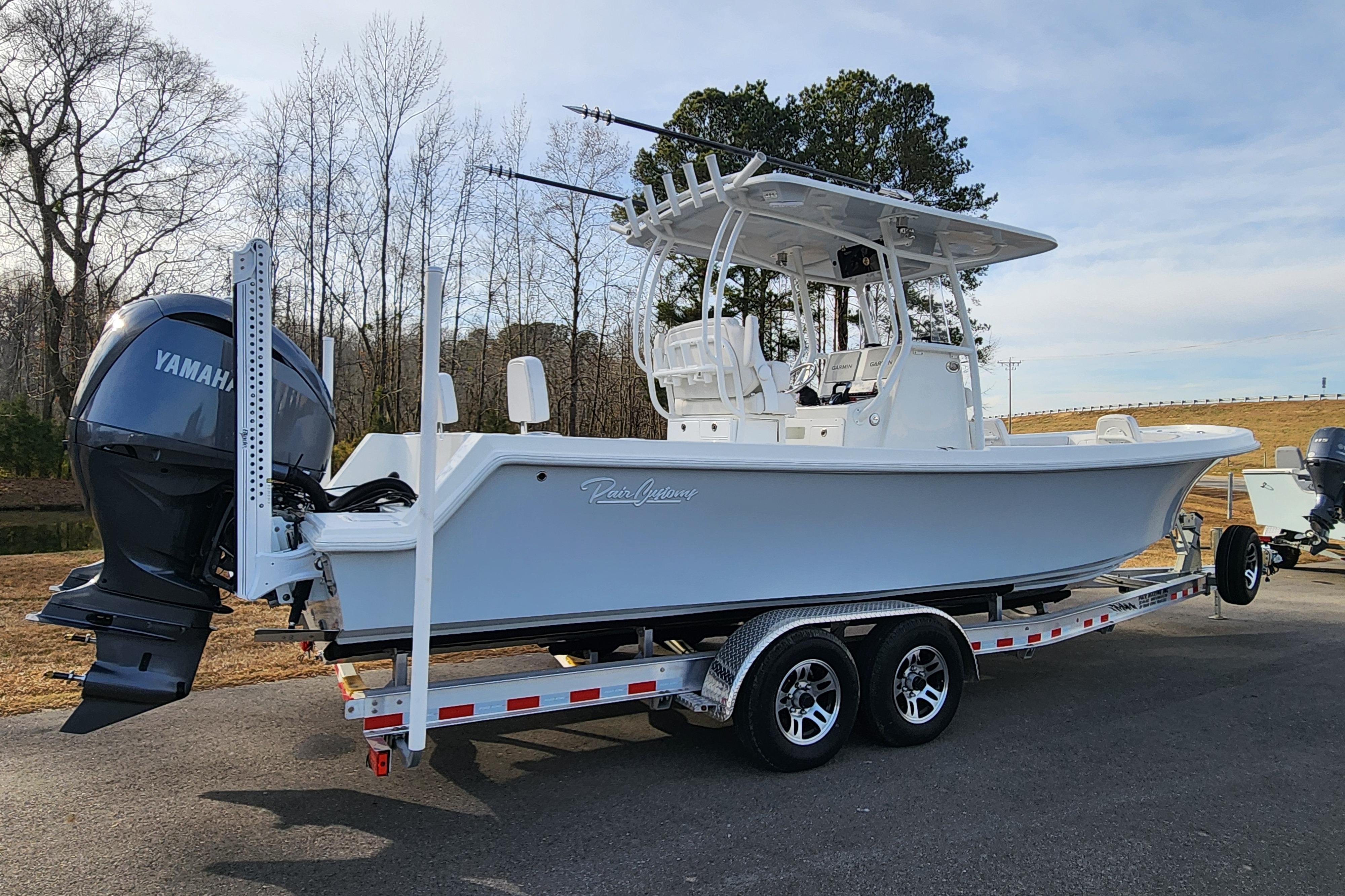 2024 Pair Customs 27 CC boat on trailer with Yamaha engine, parked outdoors.