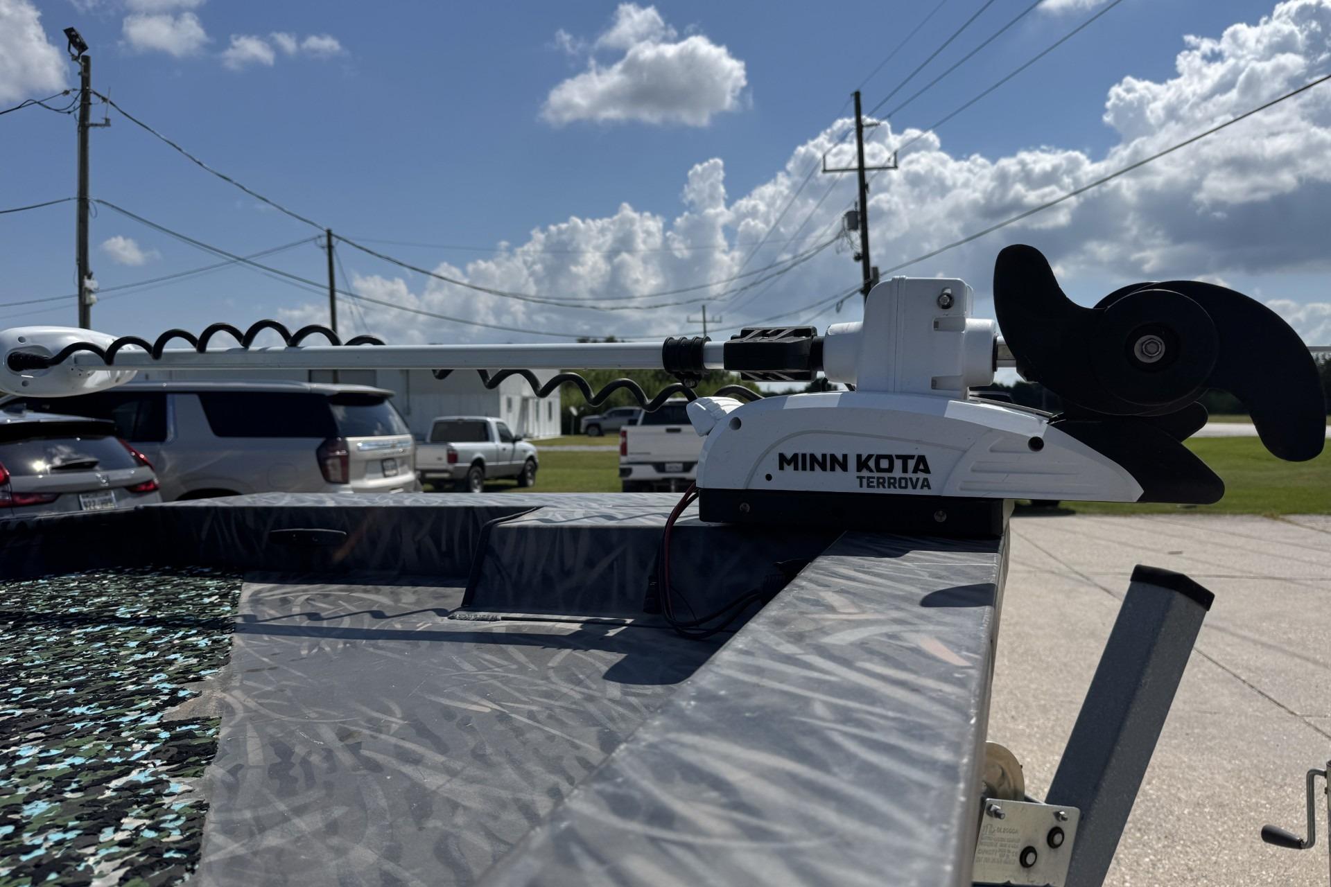2022 Alweld 2270 boat with Minn Kota Terrova motor, parked outdoors under a sunny sky.