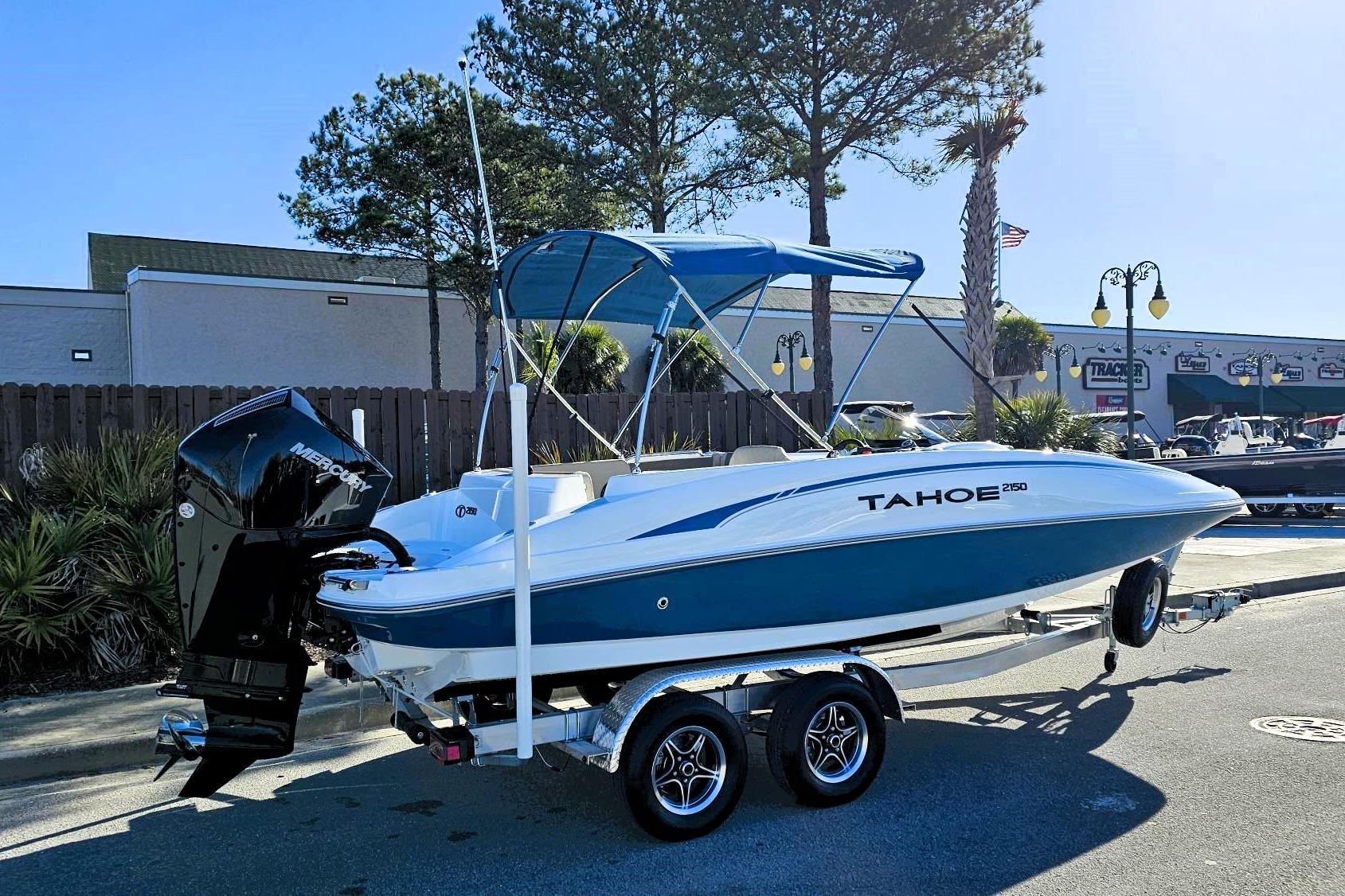 2026 Tahoe 2150 boat on trailer, blue and white design, parked outdoors.