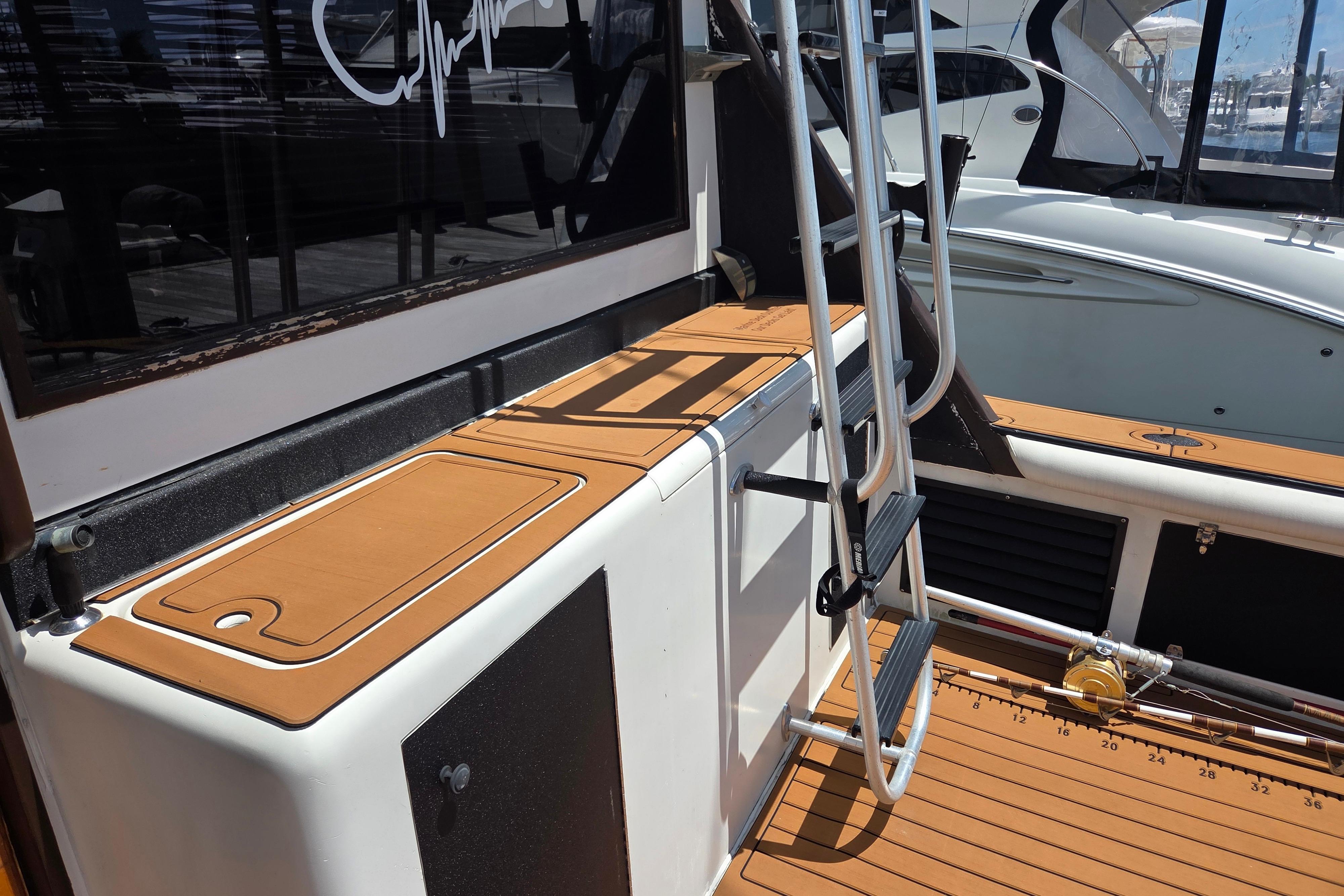 1990 Egg Harbor Golden Egg 42 boat deck with ladder and fishing rod holder.