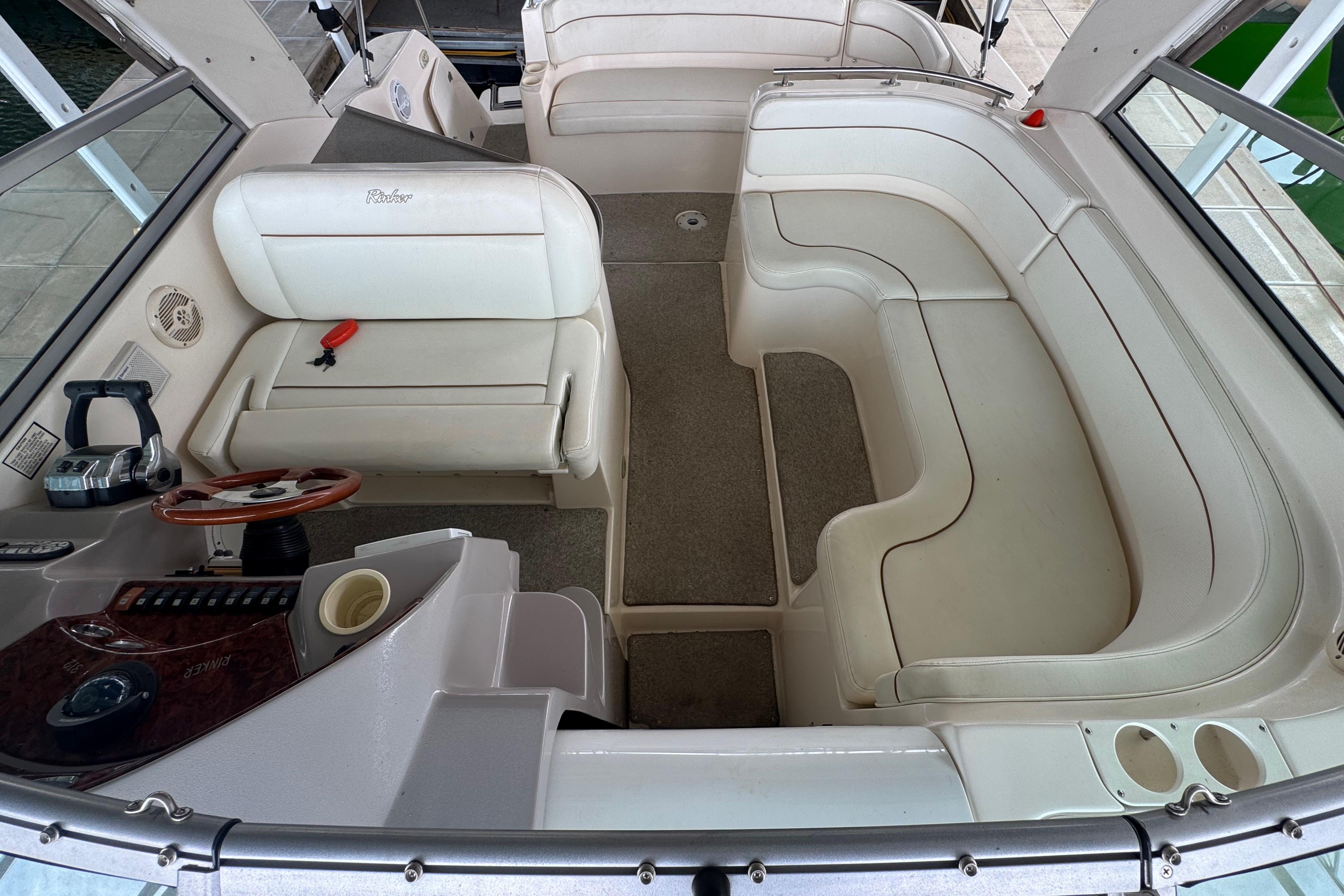 2004 Rinker Fiesta Vee 312 boat interior with white seating and steering console.