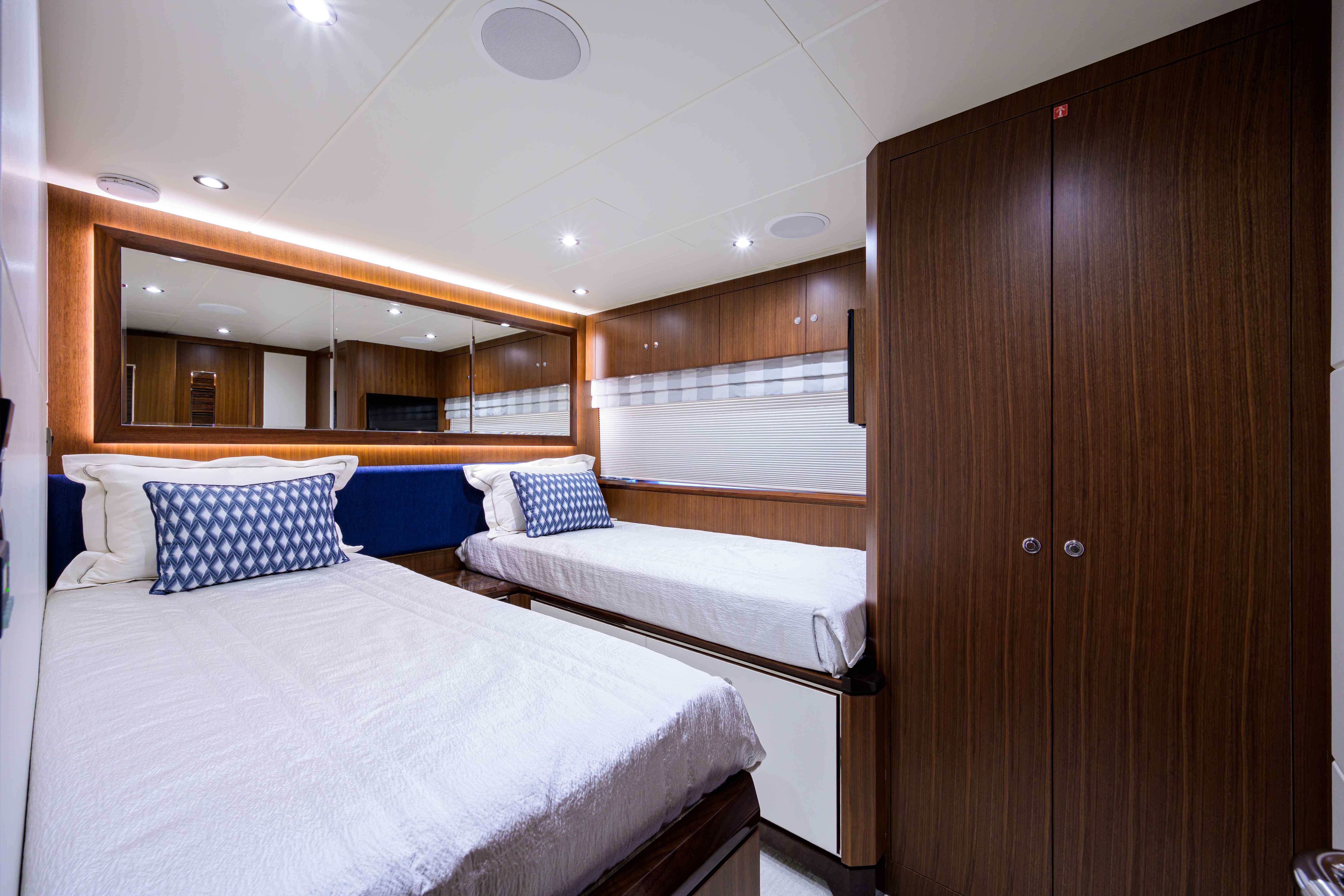 Luxurious twin cabin interior of 2019 Ocean Alexander 100 Motoryacht with elegant wood finishes.