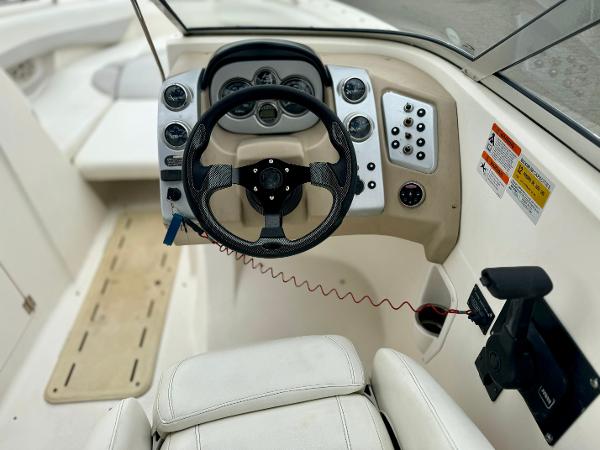 2006 Larson LXi 248 boat cockpit with steering wheel and control panel.