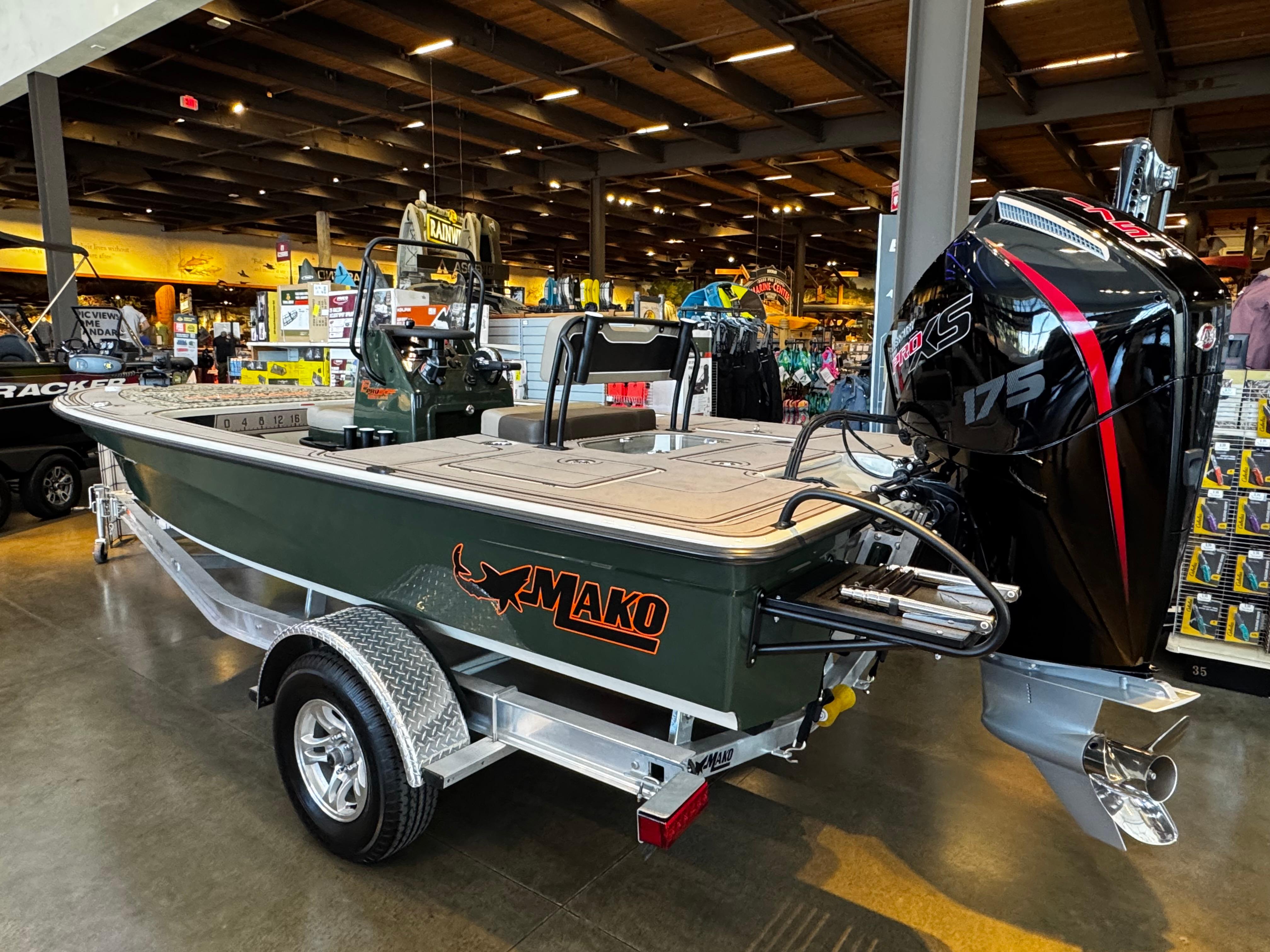 2025 Mako 18 Pro Skiff Backwater Edition boat displayed indoors with powerful outboard motor.