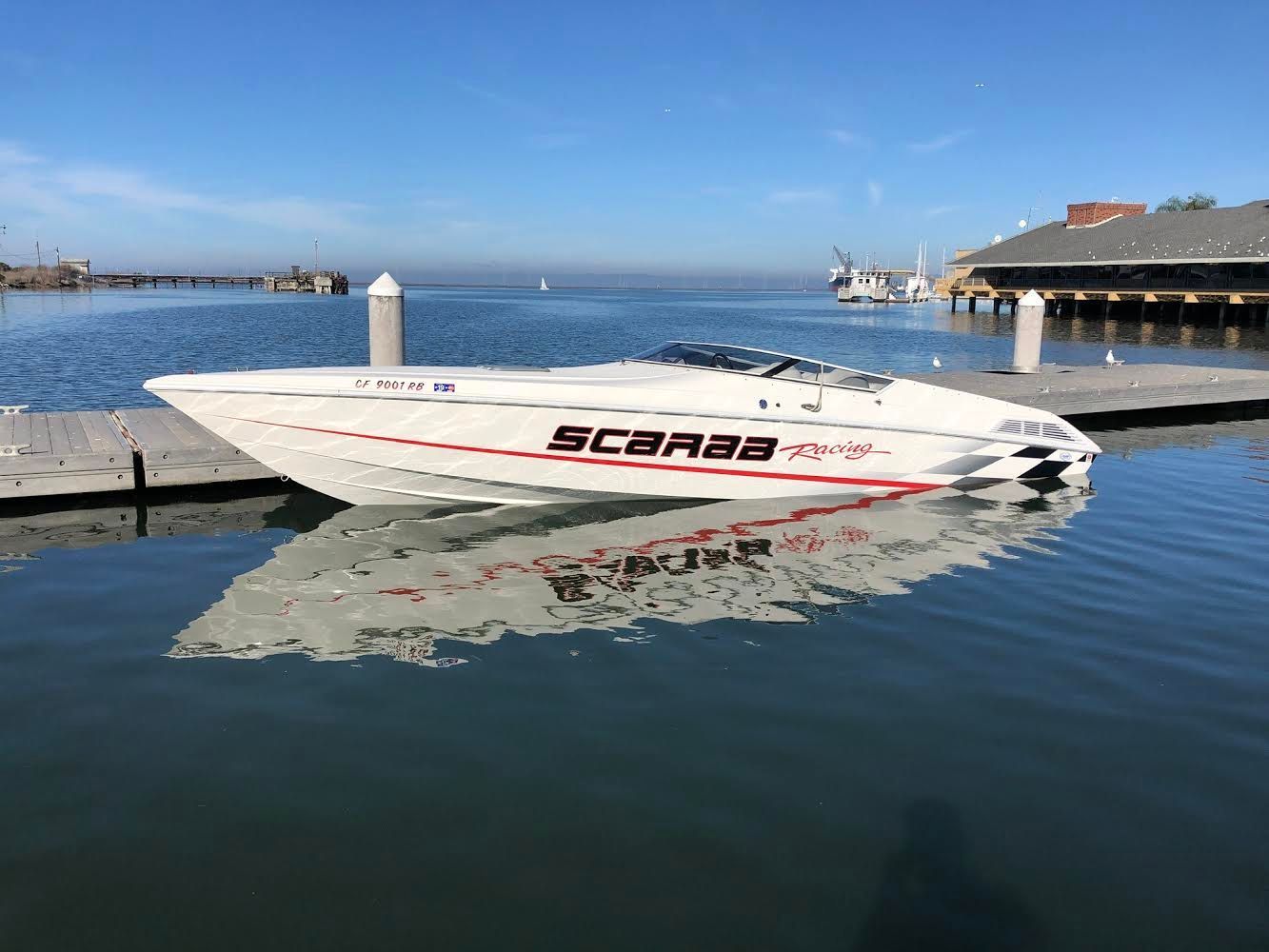 1997 Wellcraft 29 Scarab racing boat docked.