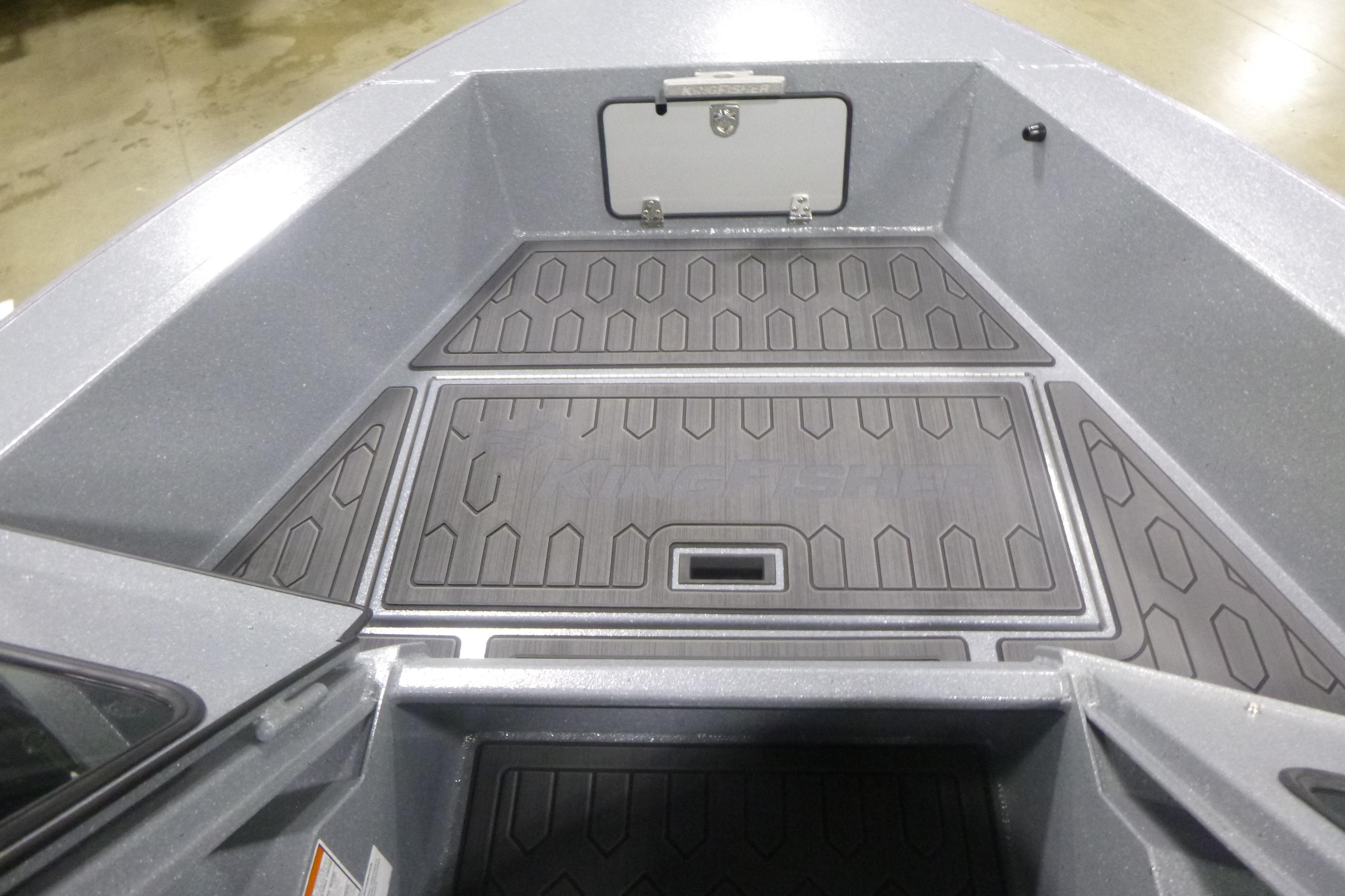 Interior view of 2026 KingFisher 2025 Falcon boat, featuring textured flooring and storage compartment.