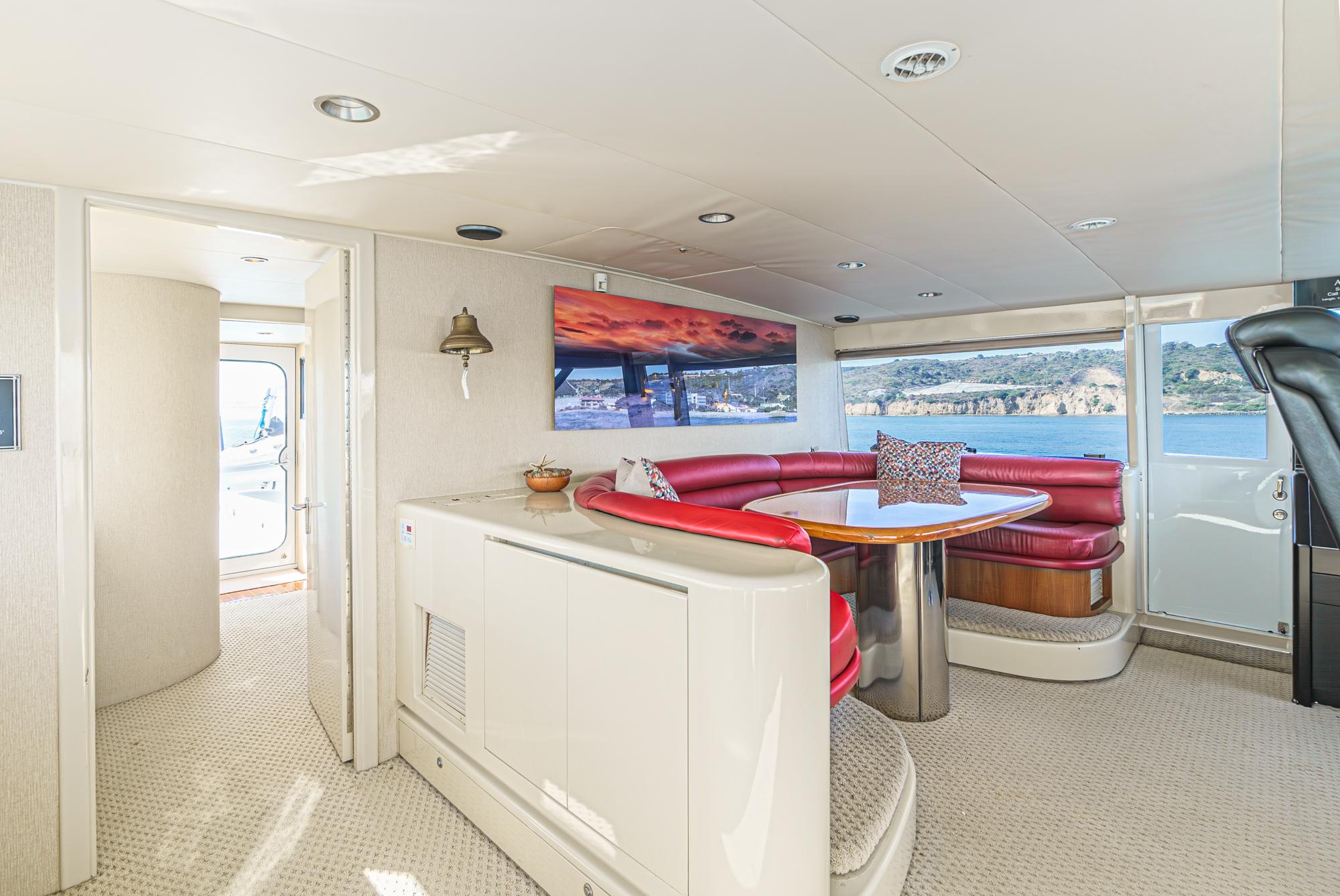 Luxurious 1992 Barattucci Yacht Fisher interior with red seating and scenic ocean view.