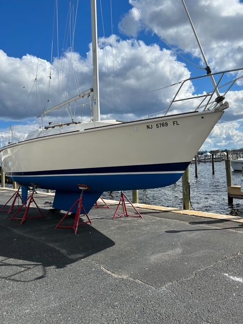 A 1988 Pearson 28 sailboat on dry dock with a blue hull.