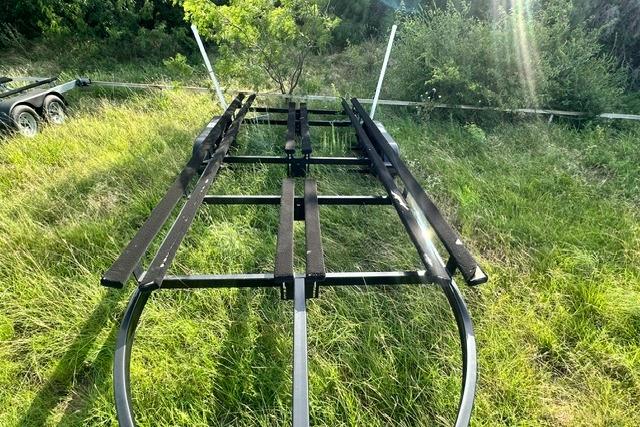 Trailer for 2019 Sun Tracker Party Barge 22 XP3 on grassy field.