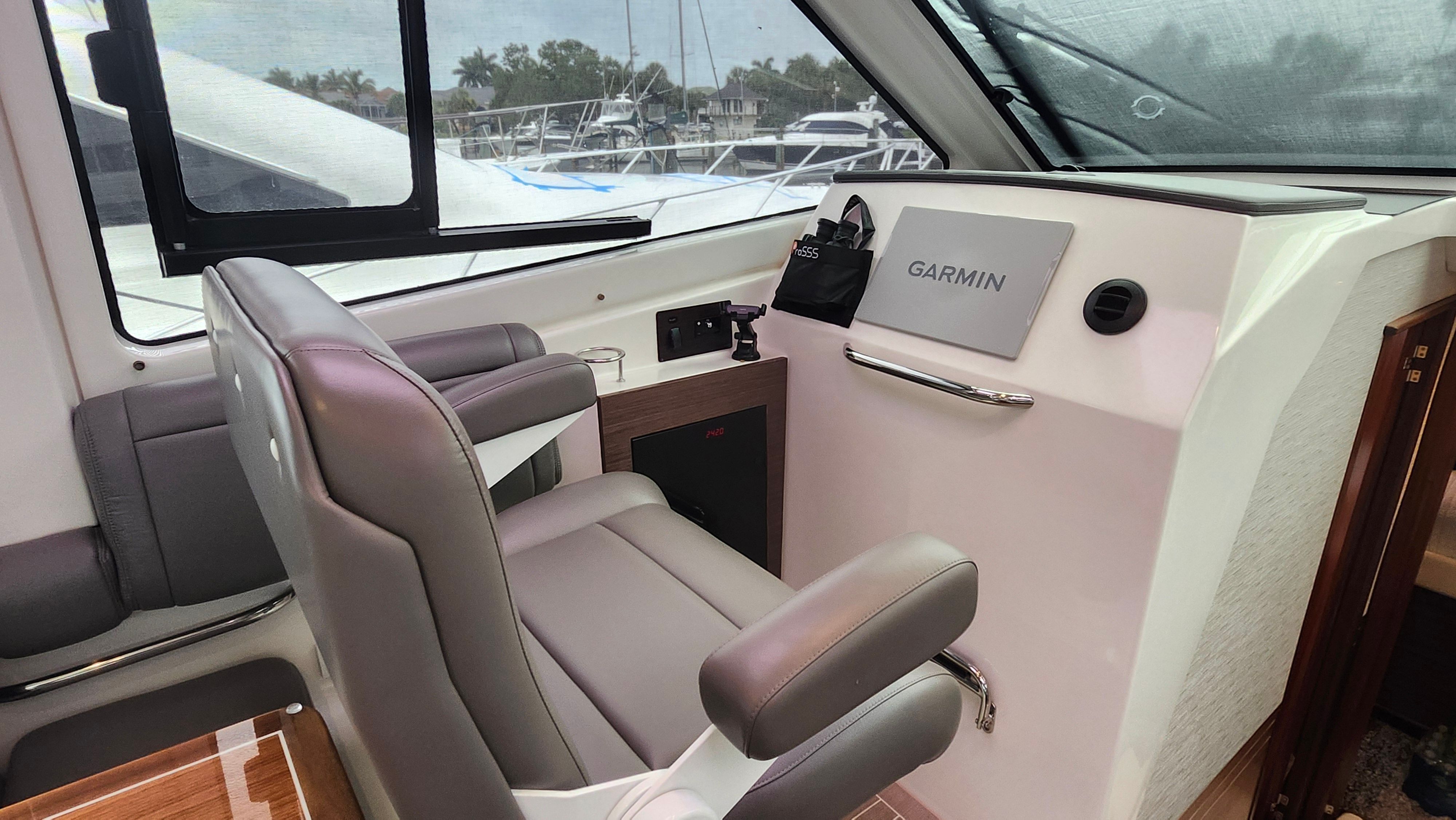 Interior of the Pursuit OS 445 Offshore with gray seating and Garmin navigation system.