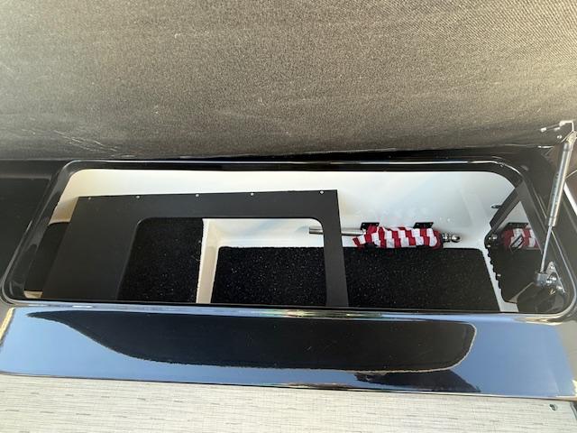 Storage compartment in a 2016 Regal 2800 Bowrider boat, featuring black interior lining.