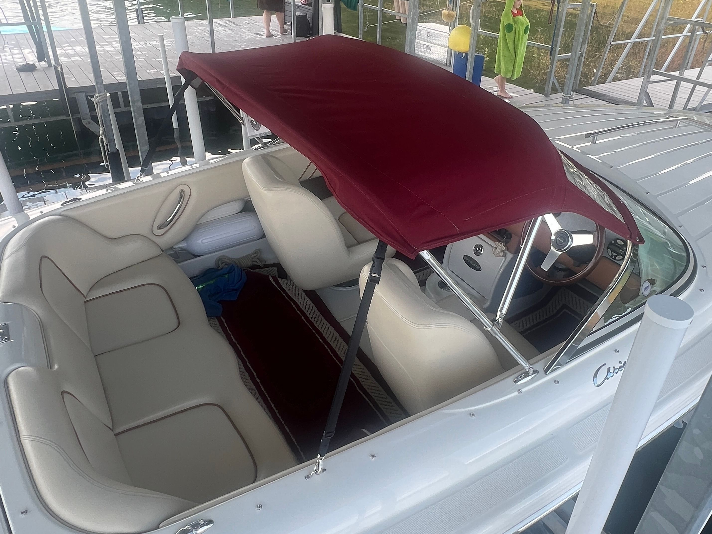 A 2006 Chris-Craft Speedster 20 with cream seats and a burgundy canopy.