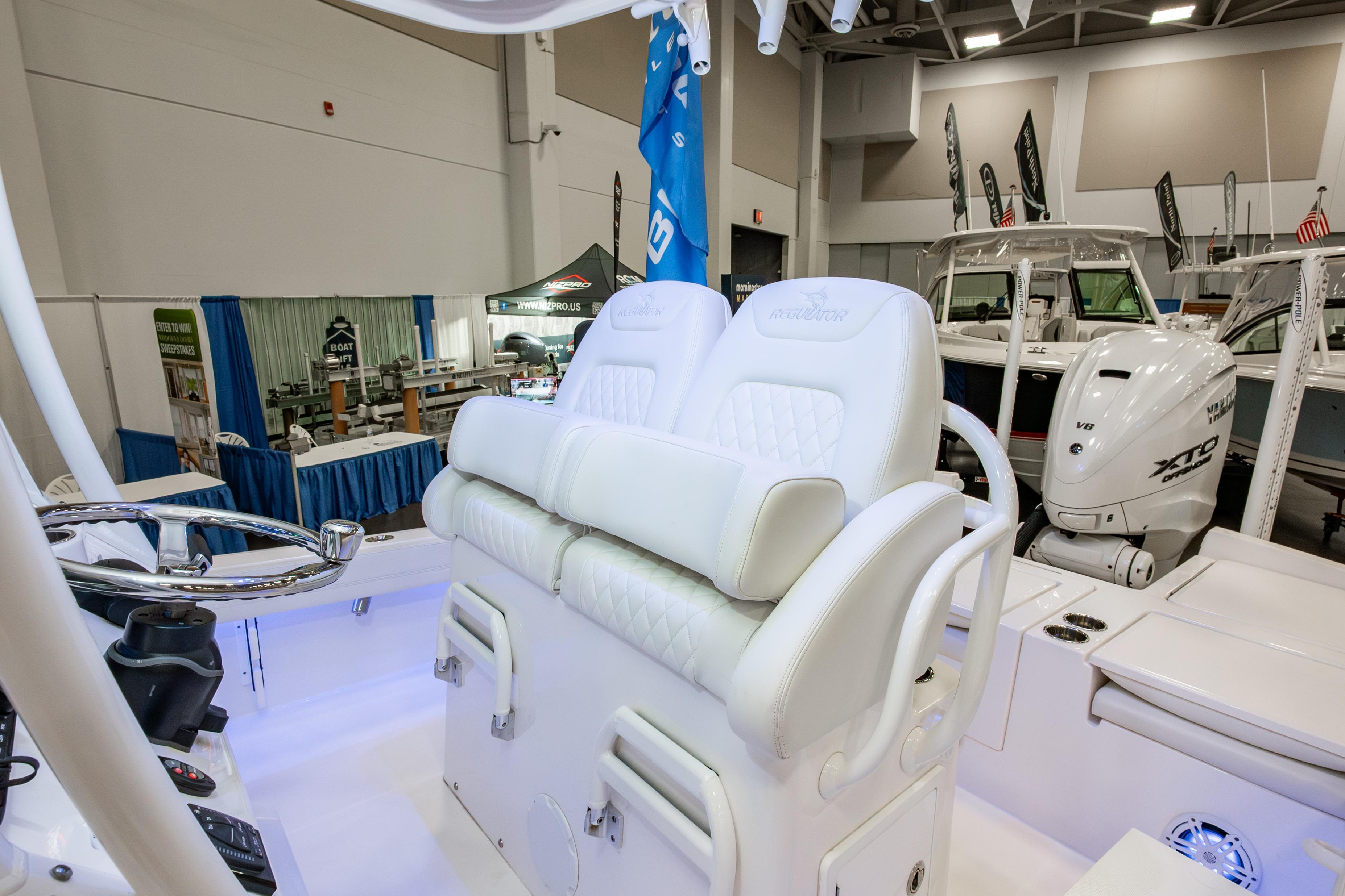2025 Regulator 26XO boat interior with white seating and steering wheel at a boat show.