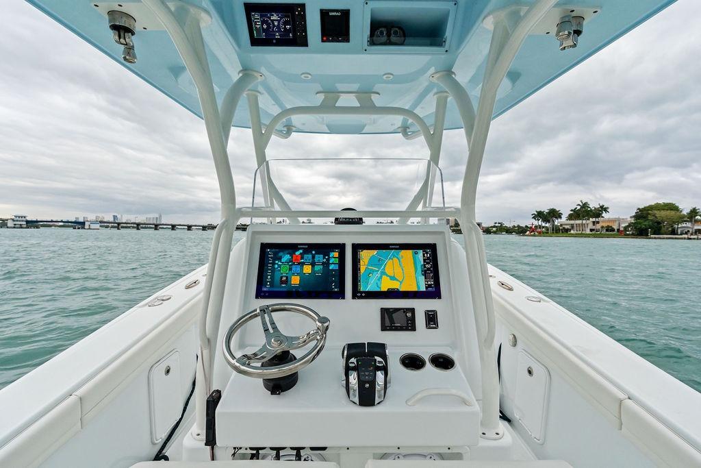 2021 Yellowfin 36 Offshore boat helm with navigation screens and steering wheel.