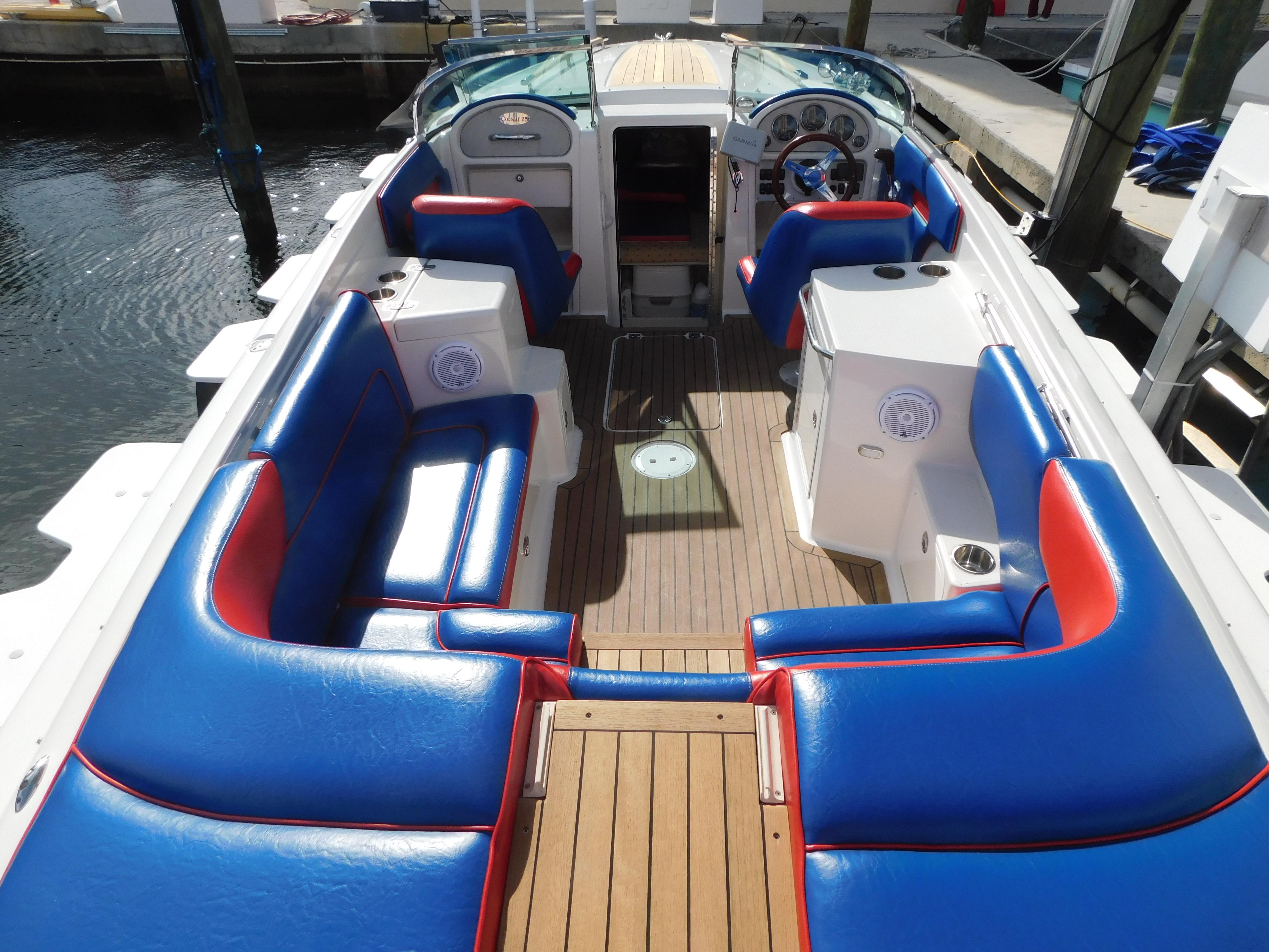 2009 Chris-Craft Corsair 25 boat with blue and red seating, docked at marina.
