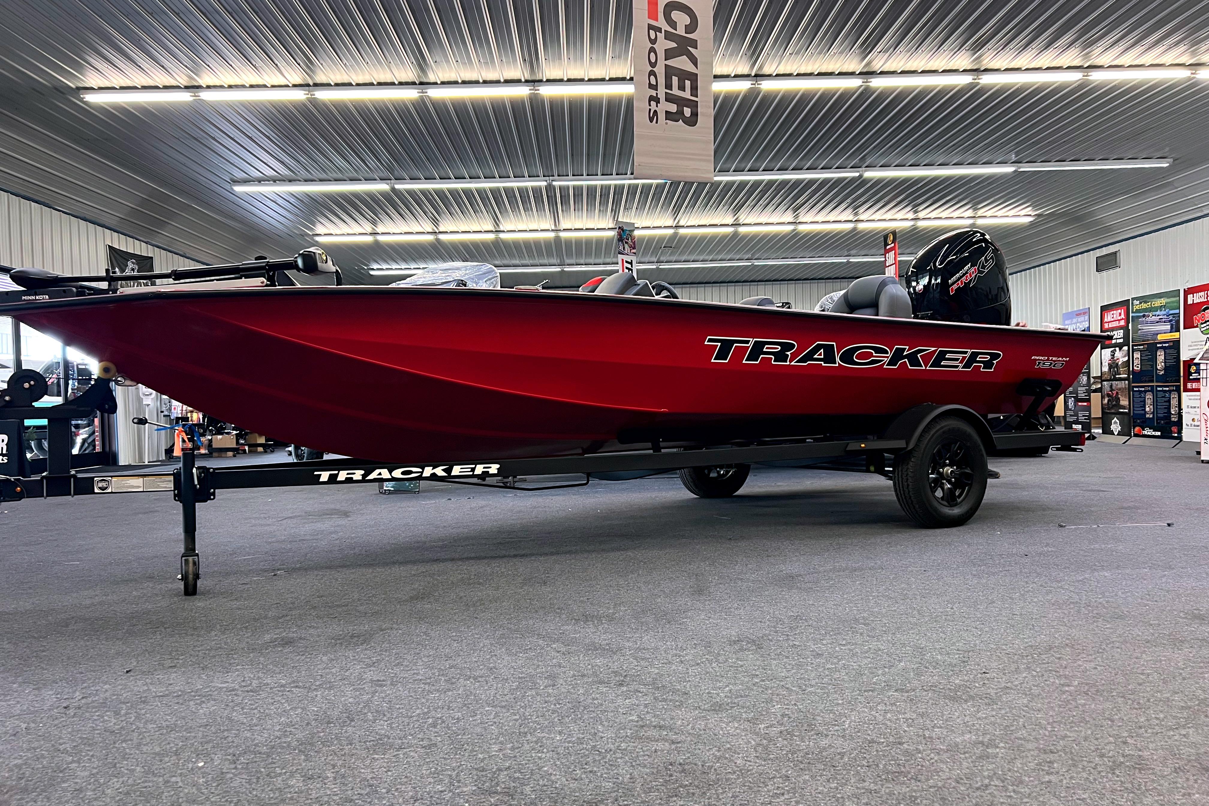 2026 Tracker Pro Team 190 boat displayed in showroom, vibrant red color.