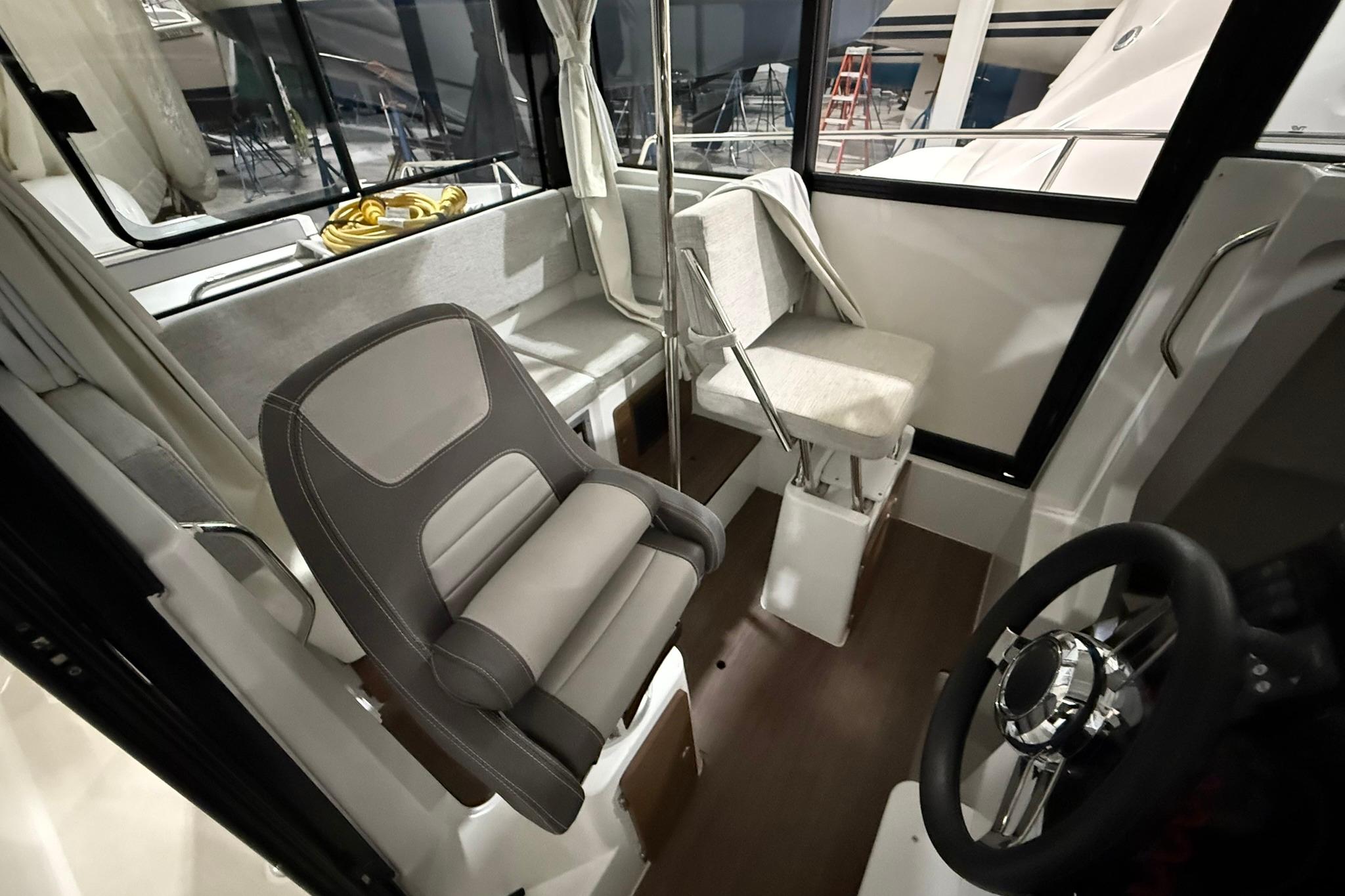 Interior of 2024 Jeanneau NC Sport 795 Series 2 boat, featuring seating and steering wheel.