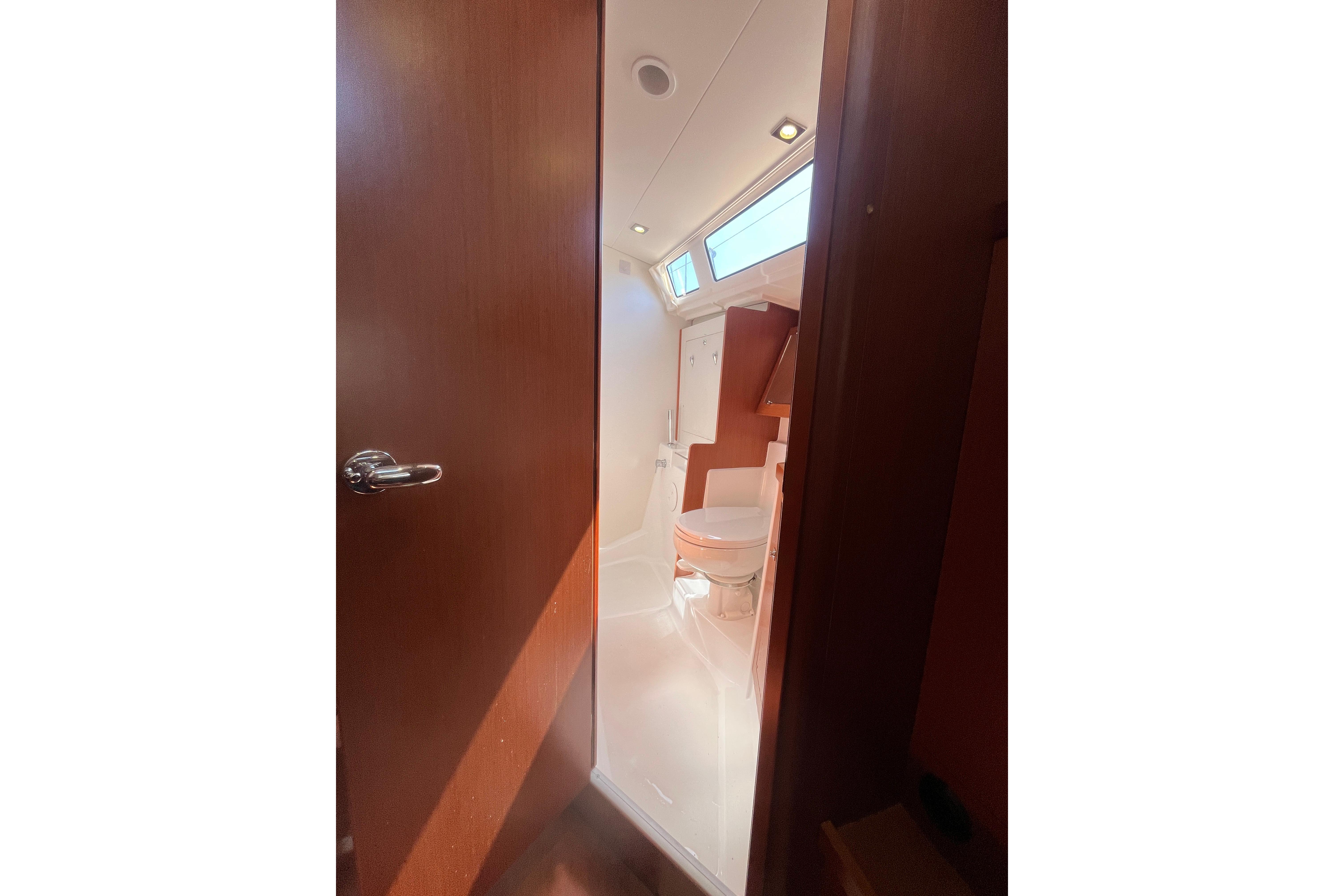Interior view of 2014 Beneteau Oceanis 45 yacht bathroom with wooden door and modern fixtures.