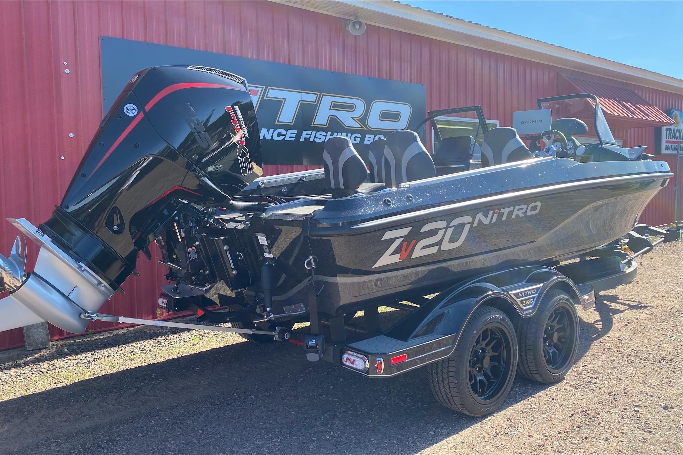 2026 Nitro ZV20 Pro fishing boat with powerful outboard motor, parked outside a red building.