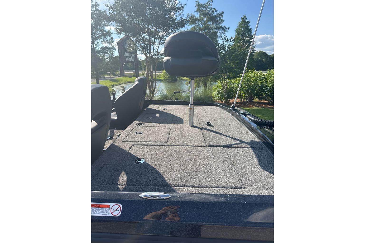 2026 Nitro Z21 XL boat deck with seating, outdoors near a pond and greenery.