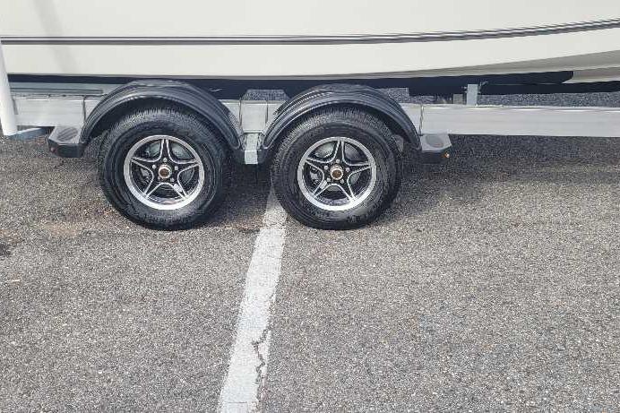 Trailer wheels of 2026 Mako 214 Center Console boat on asphalt.