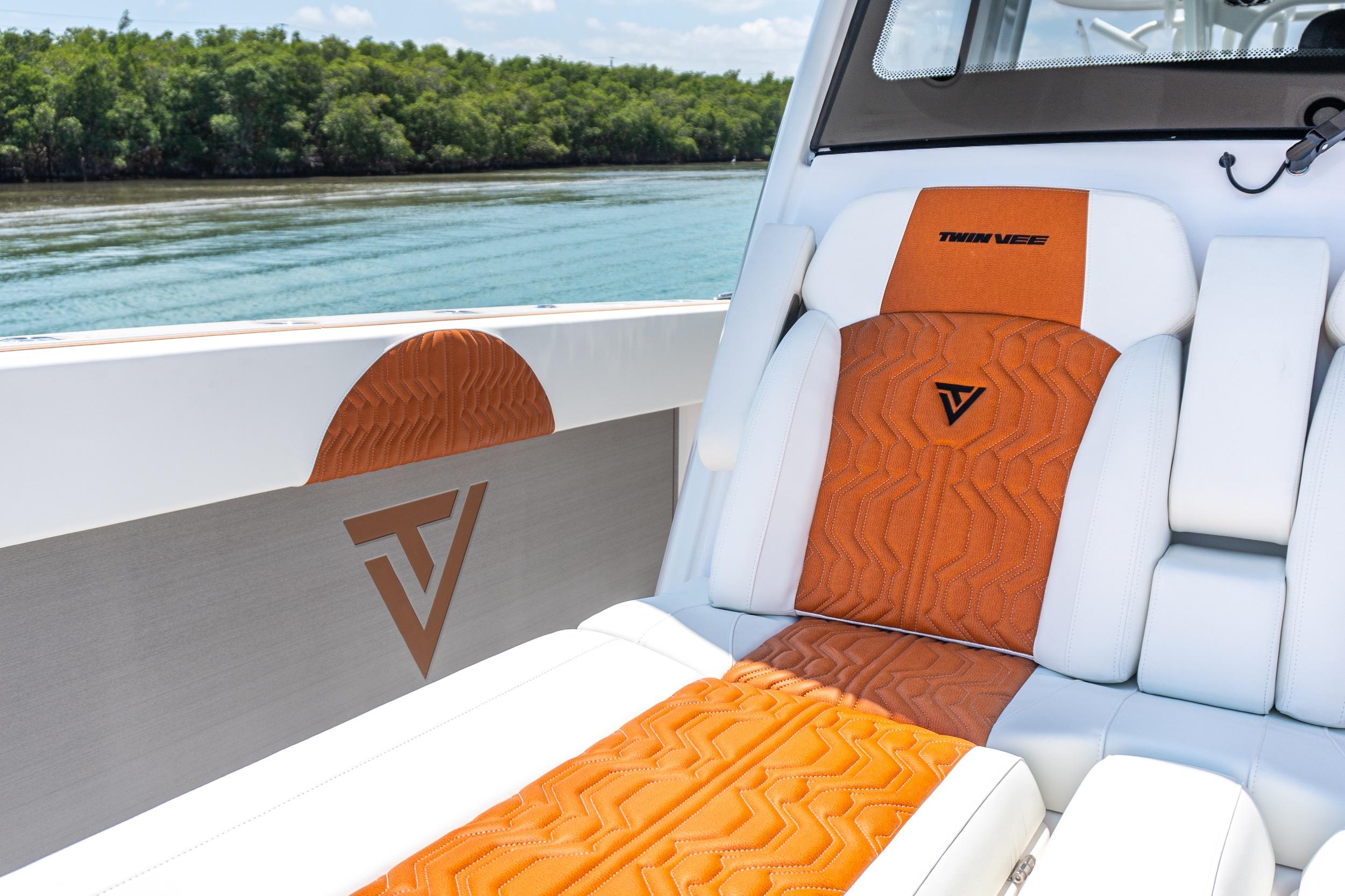 2026 Twin Vee 400 GFX2 CC boat interior with orange and white seating, logo detail.