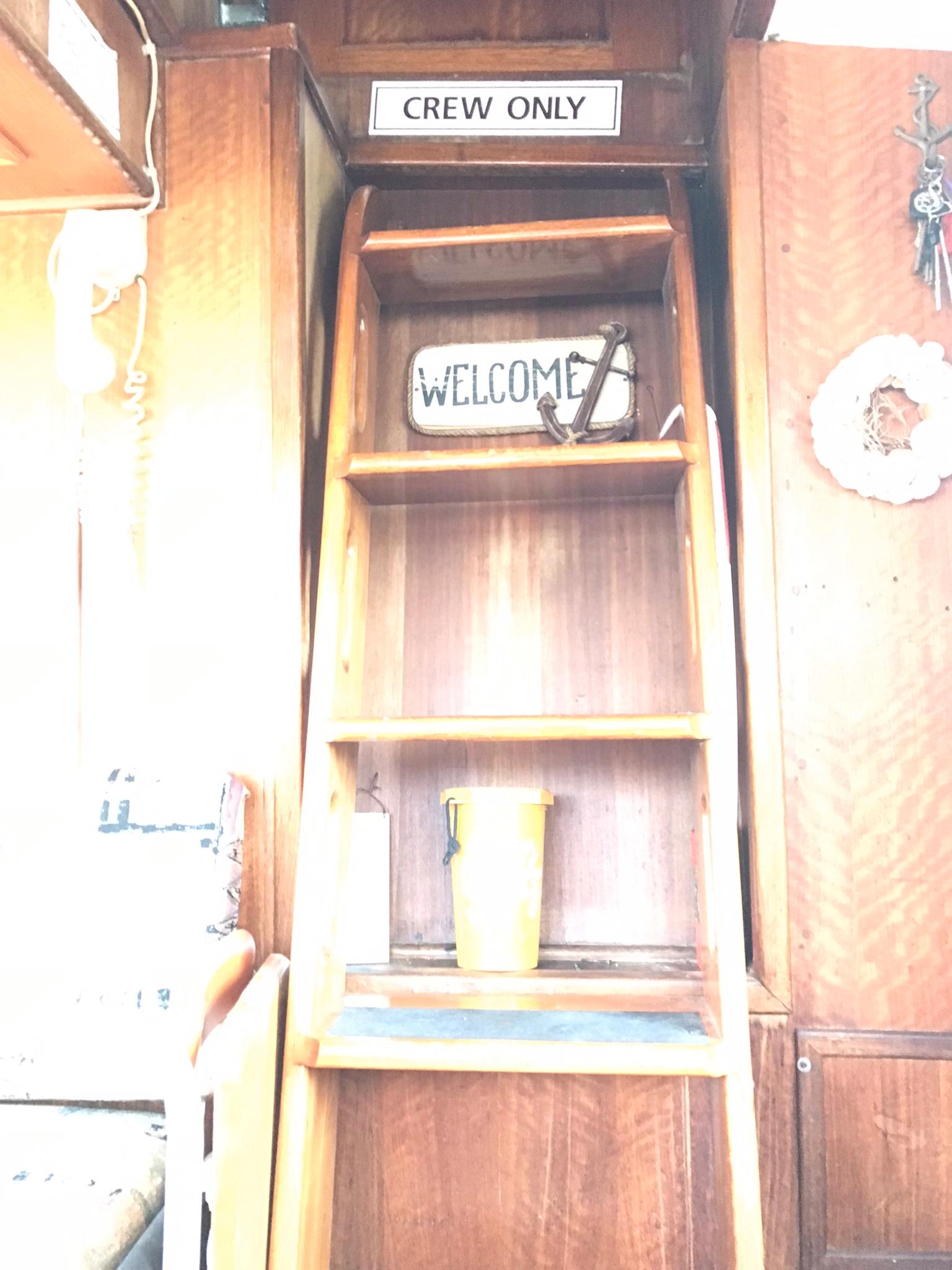 1978 Hatteras 58 MY interior with 'Crew Only' and 'Welcome' signs on wooden shelves.
