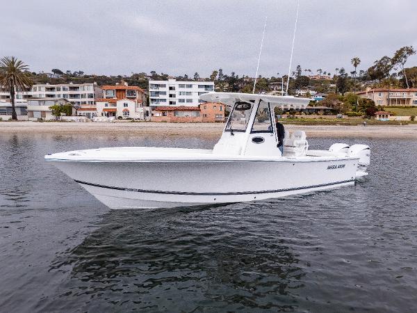 2025 Regulator 28 boat on water near coastal homes.