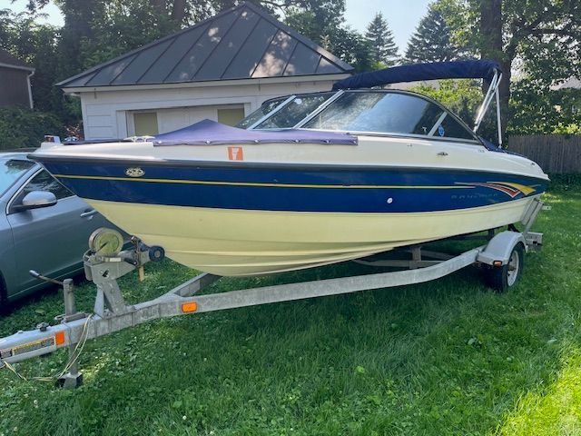 A 2007 Bayliner 185 boat on a trailer in a grassy yard.