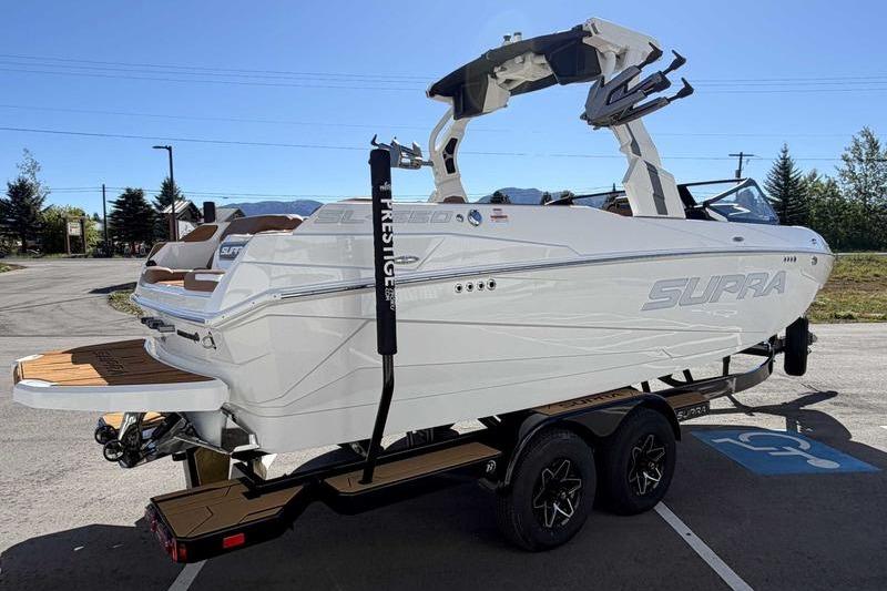 2026 Supra SL boat on trailer, white exterior, parked outdoors under clear sky.