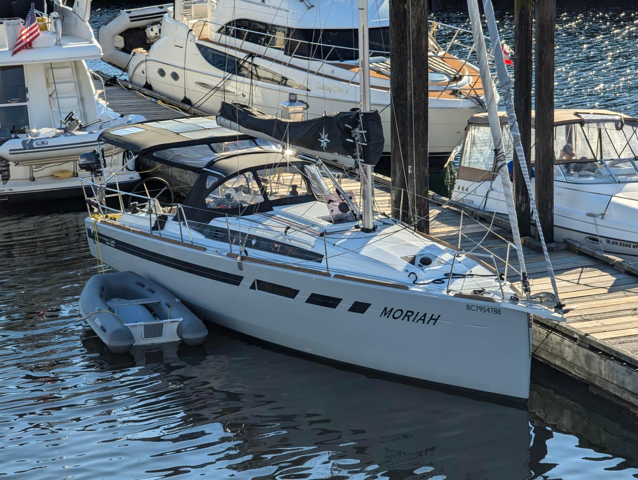 2021 Jeanneau Sun Odyssey 349 sailboat docked with inflatable dinghy alongside.