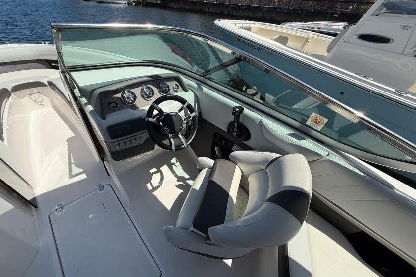 2014 Regal 2500 Bowrider boat interior with steering wheel and dashboard, docked by the water.