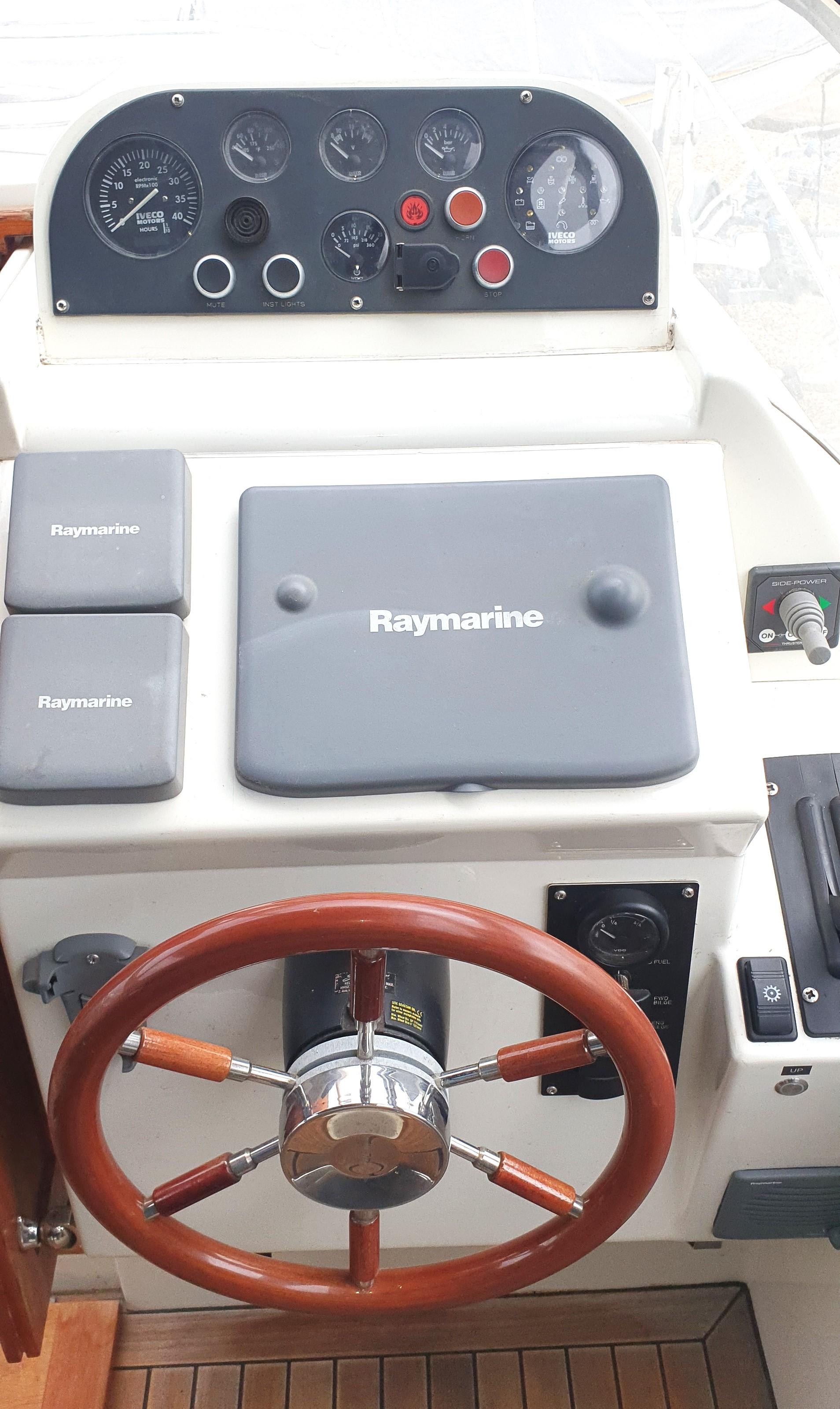 Boat control panel with Raymarine equipment and wooden steering wheel, Swordsman 30, 2006 model.