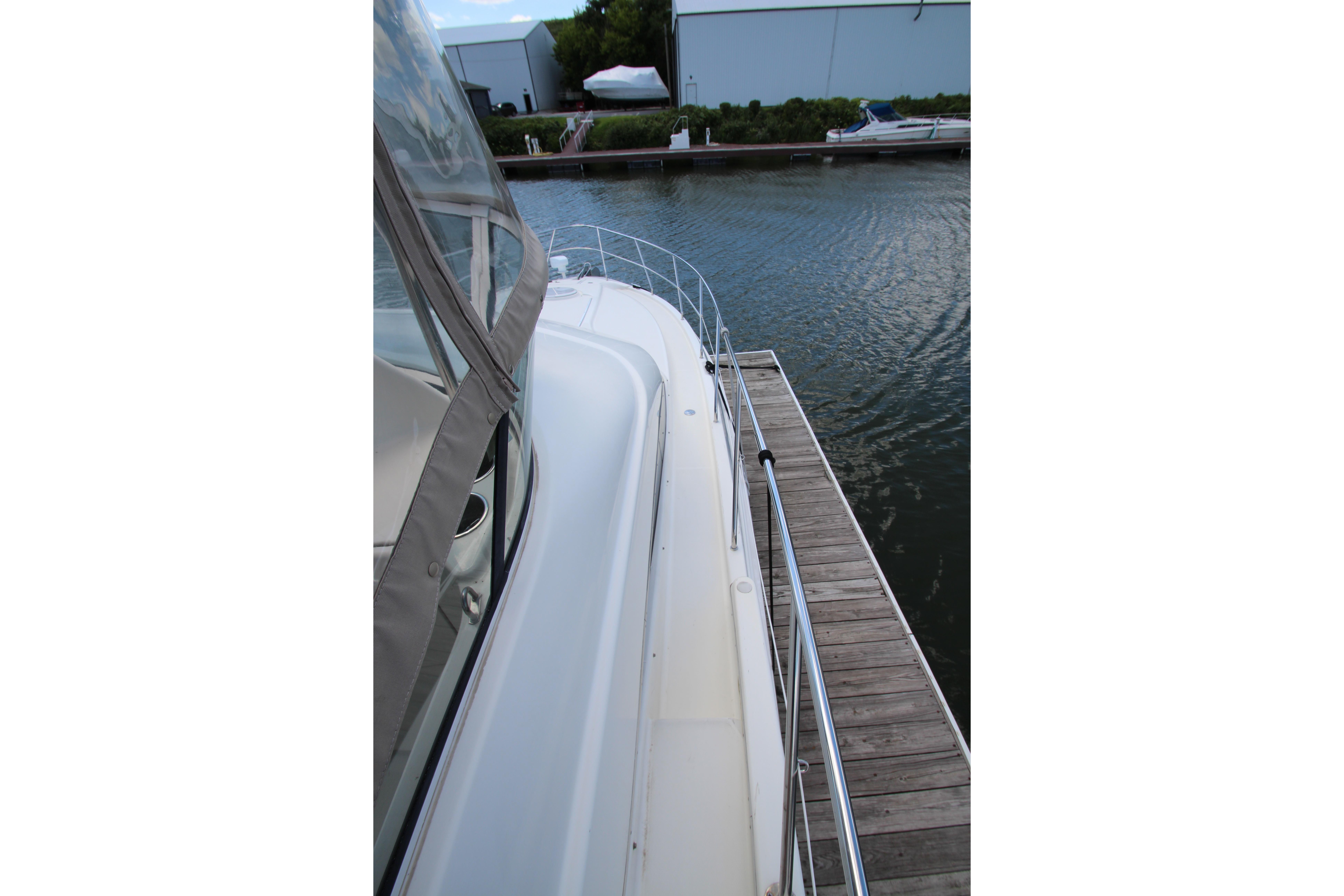 2006 Silverton 38 Sport Bridge yacht docked at marina, side view.