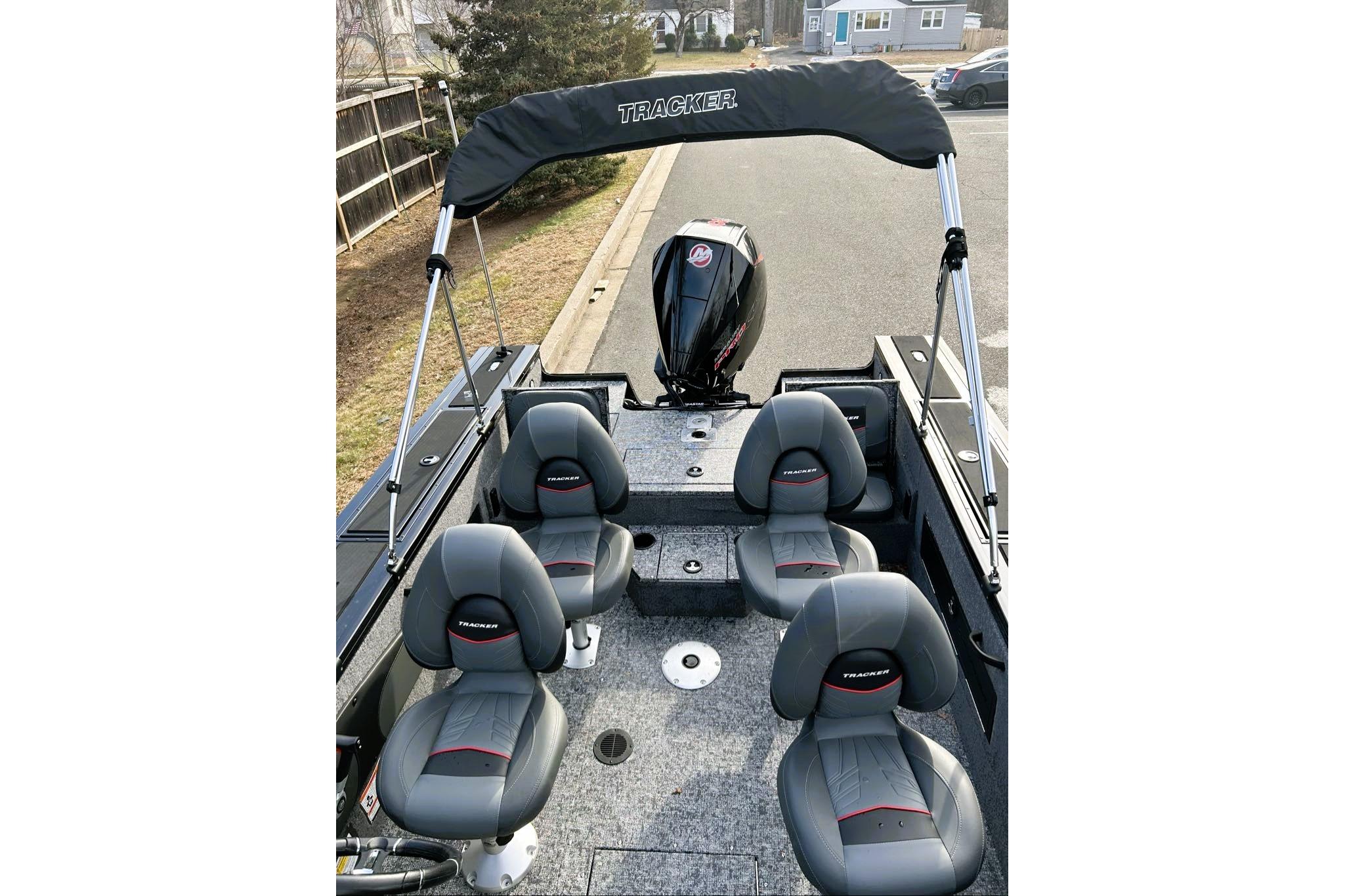 2026 Tracker Targa V-18 Combo boat interior with seating and motor, parked outdoors.