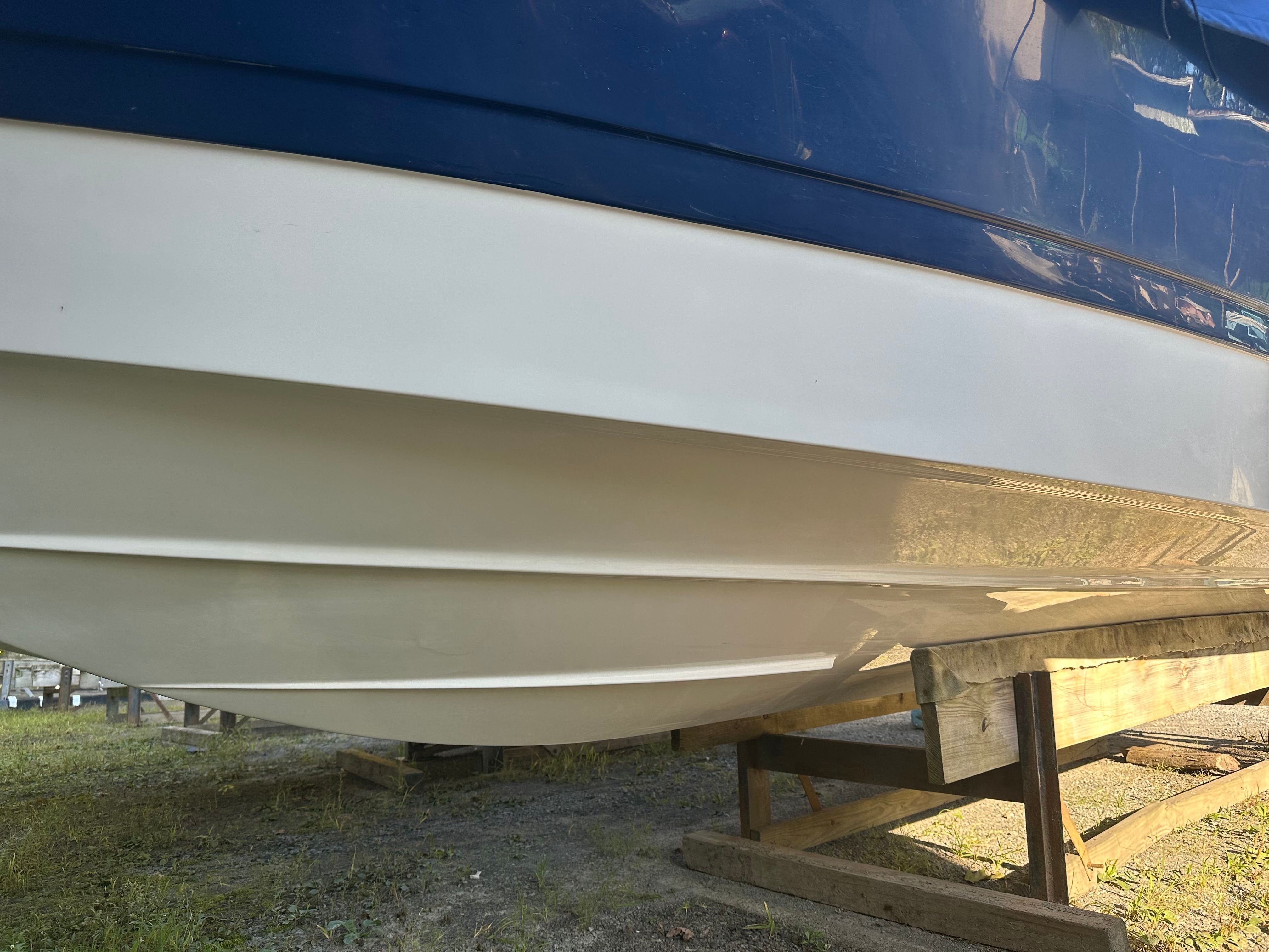2012 Four Winns H210 boat hull on wooden stand.