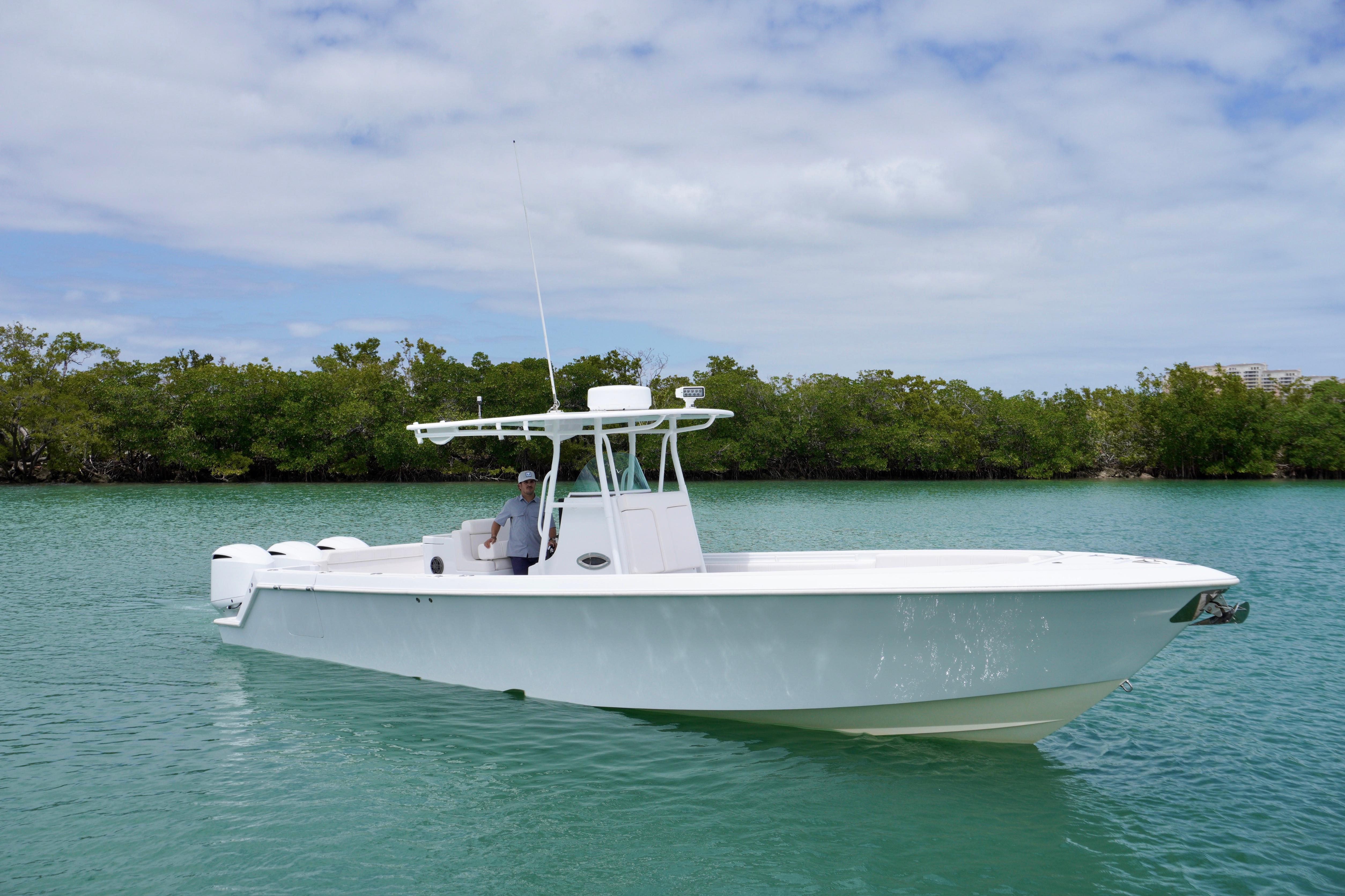 2013 Contender 35 LS boat on calm water, surrounded by lush greenery.
