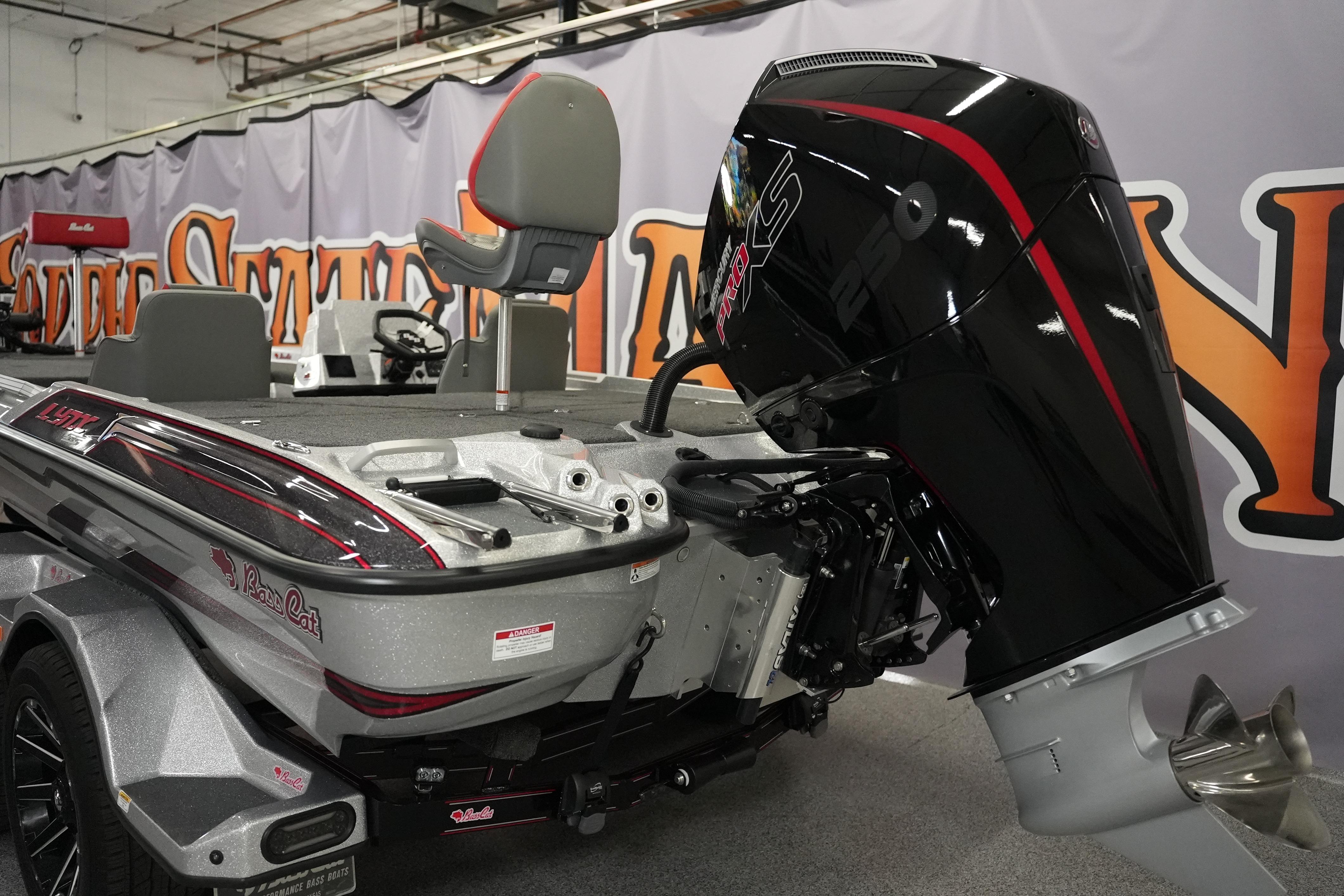 2026 Bass Cat Lynx STS boat with powerful outboard motor in showroom.