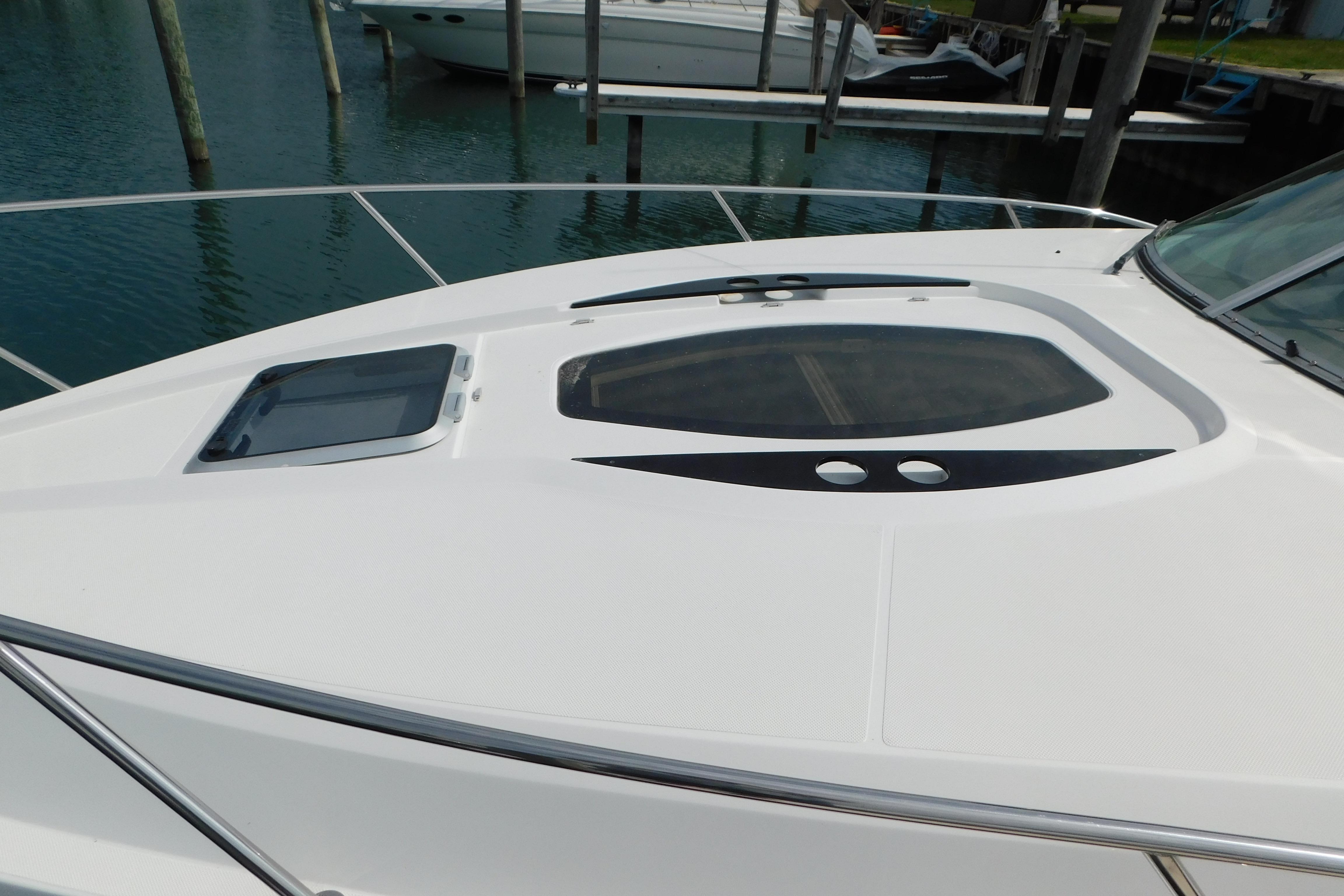 2017 Rinker EX 320 boat deck with hatch, docked in marina.