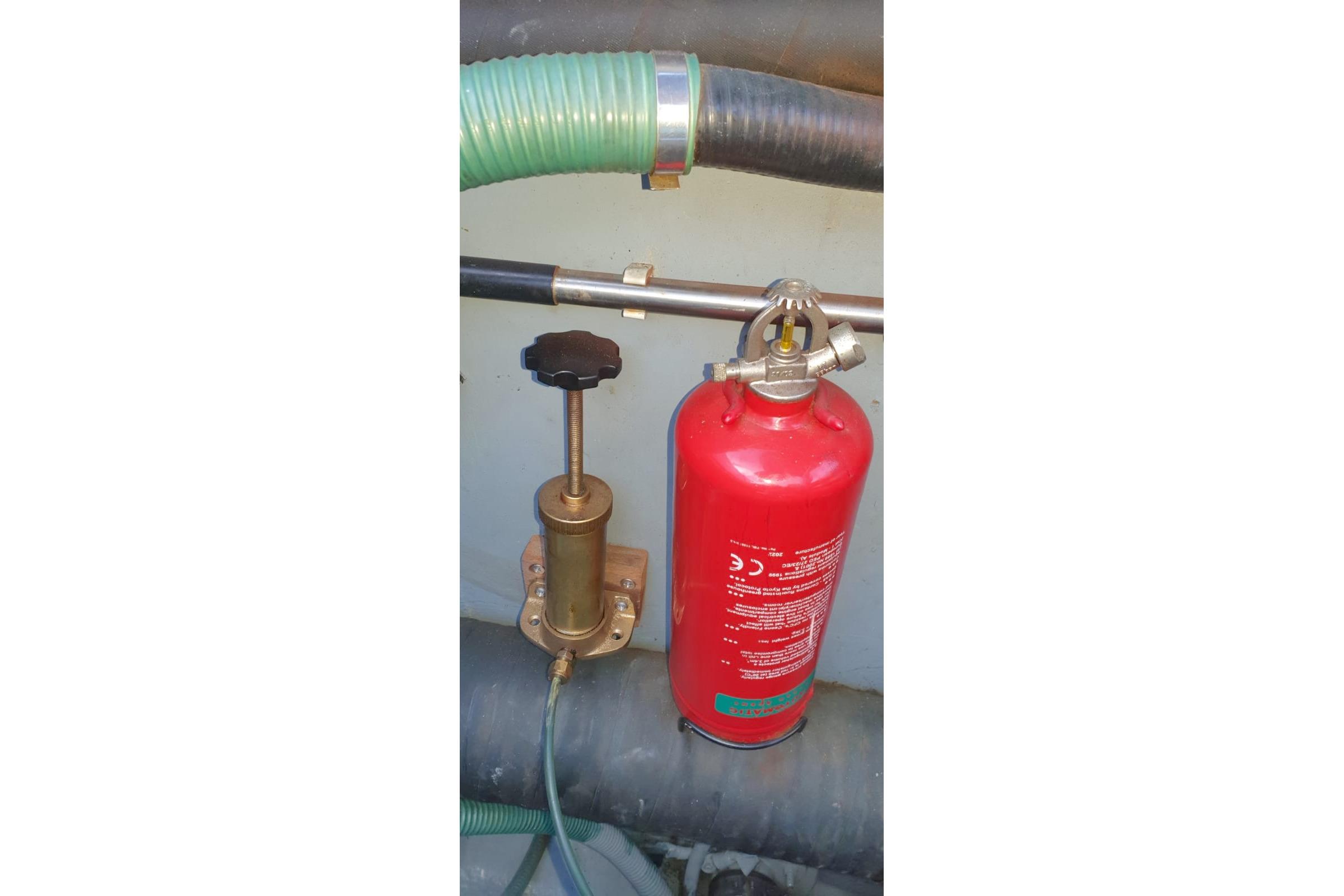 Red fire extinguisher and brass valve in Fairey Spearfish MKIII, 1989 model.