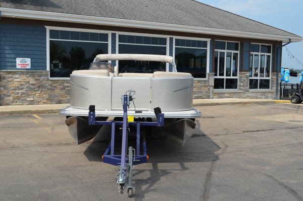 2018 Tahoe LTZ 2285 CR pontoon boat on trailer in front of building.
