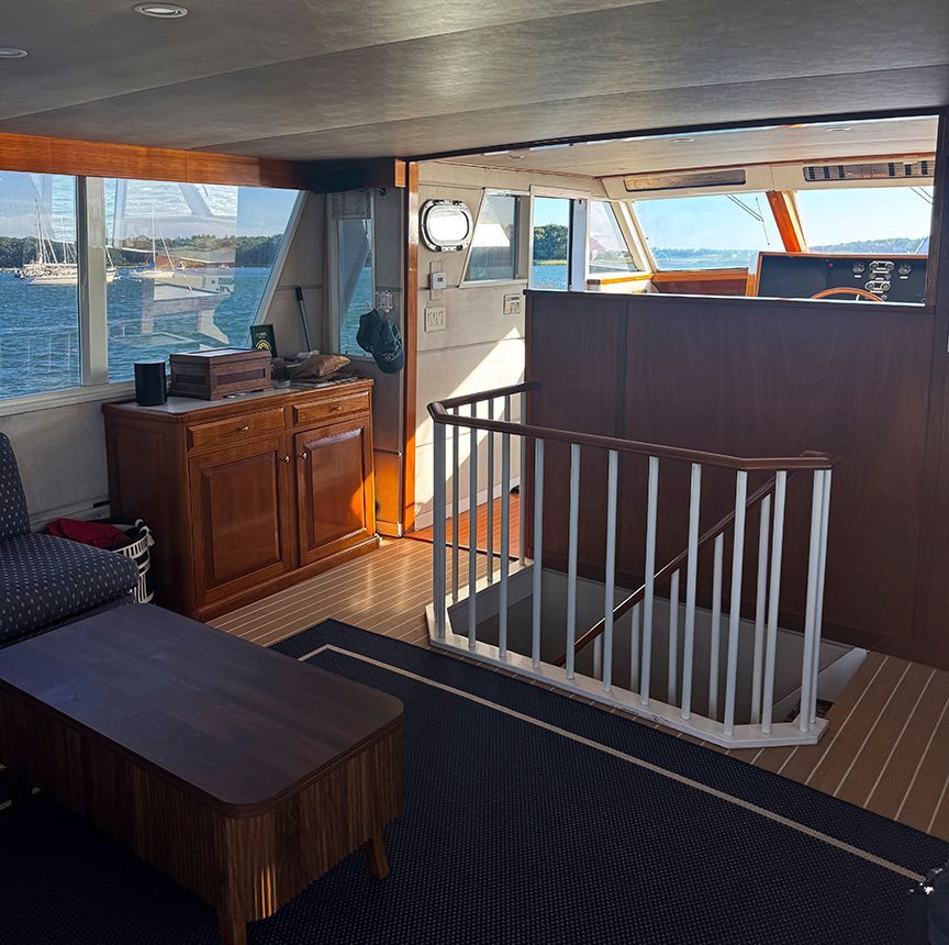 Interior of a 1961 Burger 63 yacht with wooden furniture and staircase.