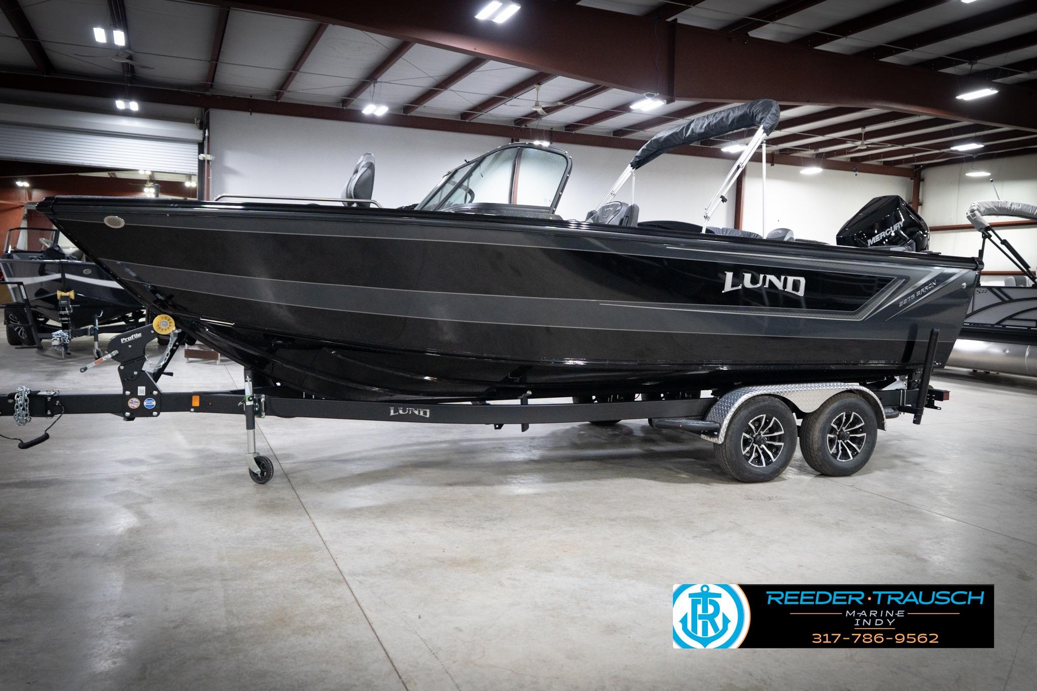 2026 Lund 2275 Baron boat on trailer in indoor showroom.