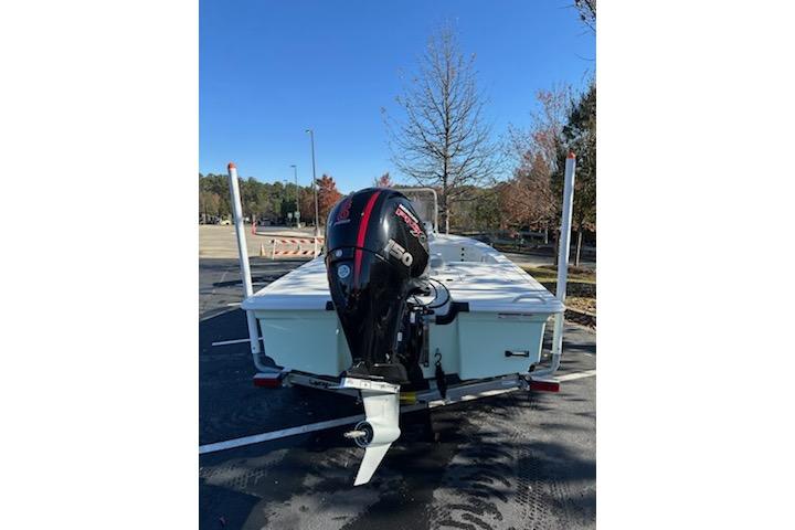 2026 Mako 18 Pro Skiff boat with outboard motor in a parking lot.