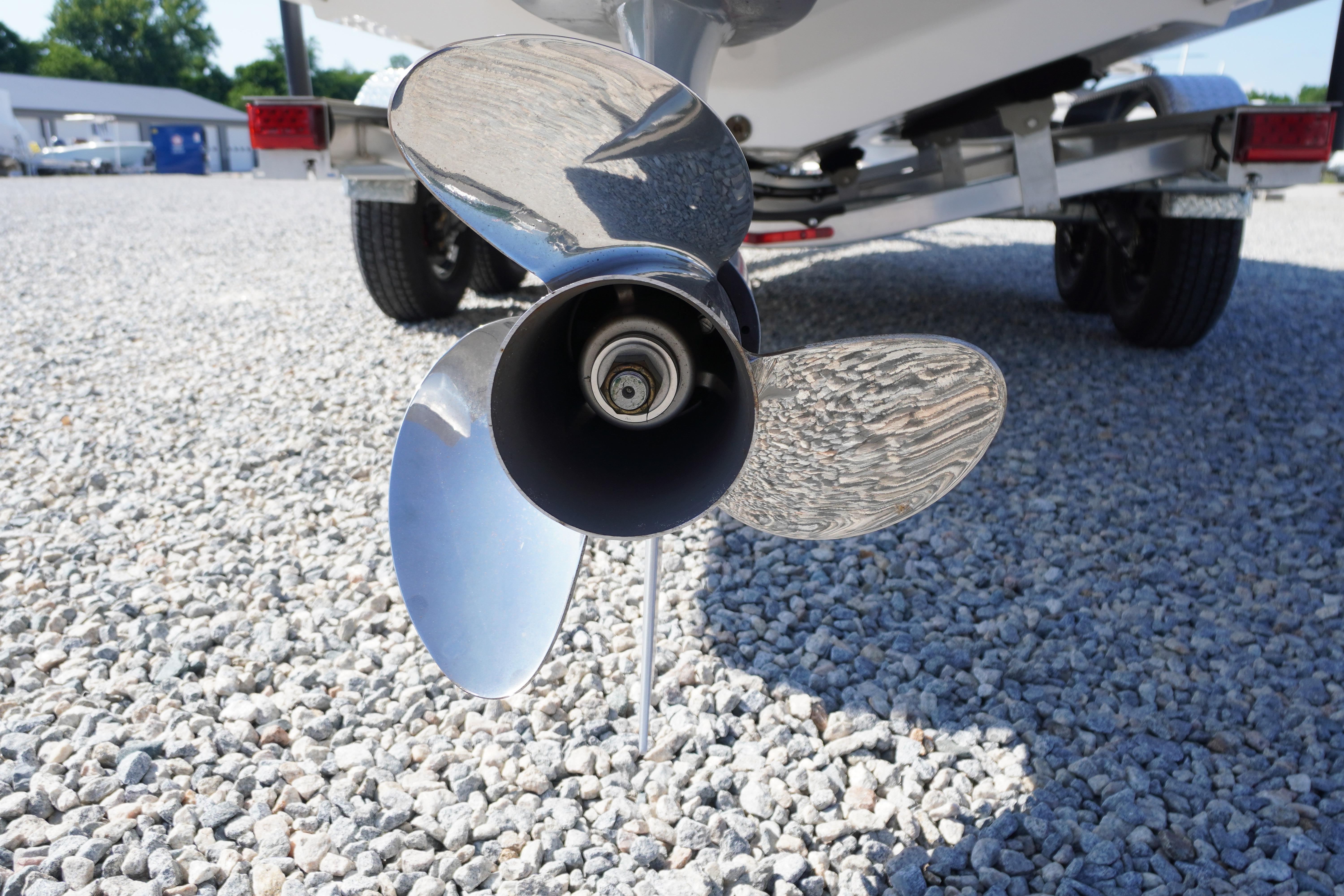 2026 Chaparral 270 OSX boat propeller on gravel surface, close-up view.