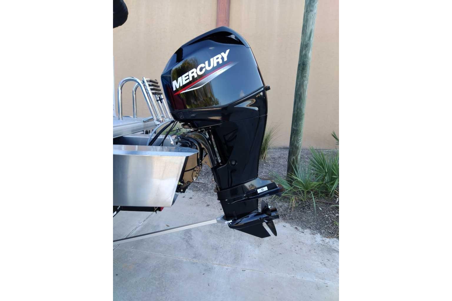 2026 Sun Tracker Party Barge 16 DLX with Mercury outboard motor, parked outdoors.