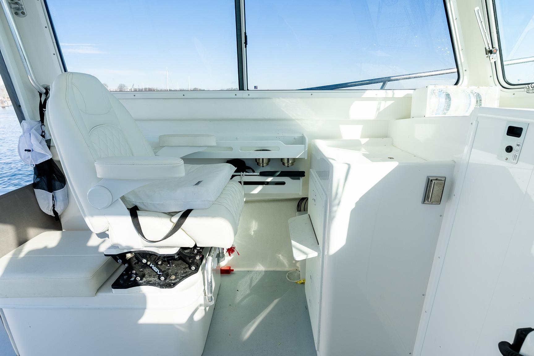 2024 Steiger Craft 31 Fisherman interior with white captain's chair and control panel.