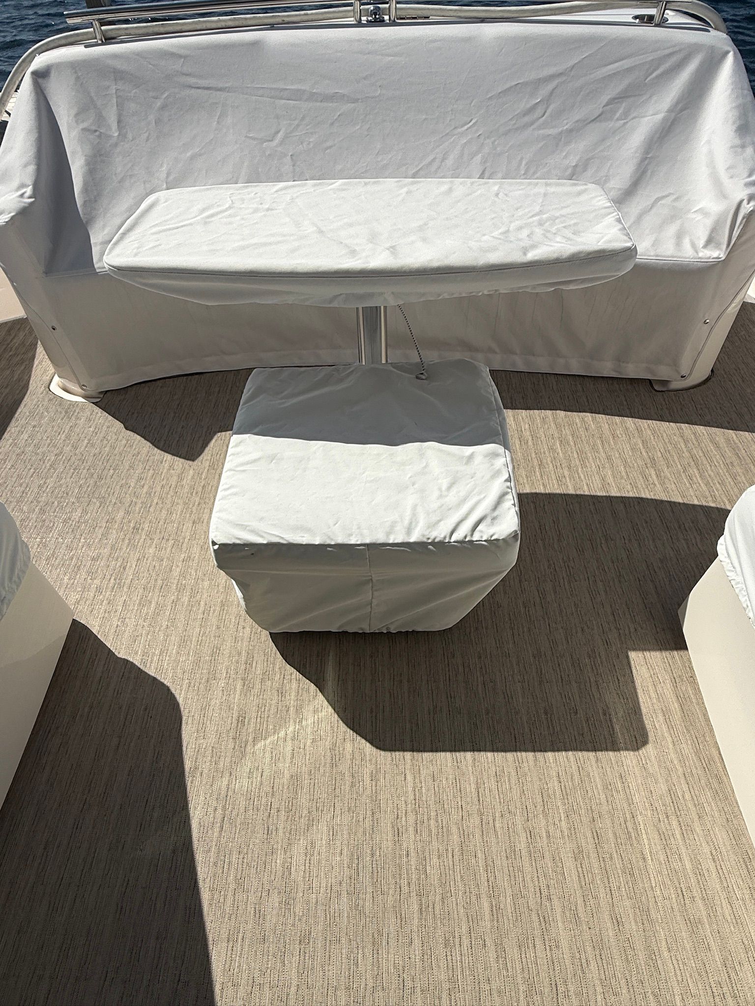 Covered table and seat on a boat with wooden flooring.